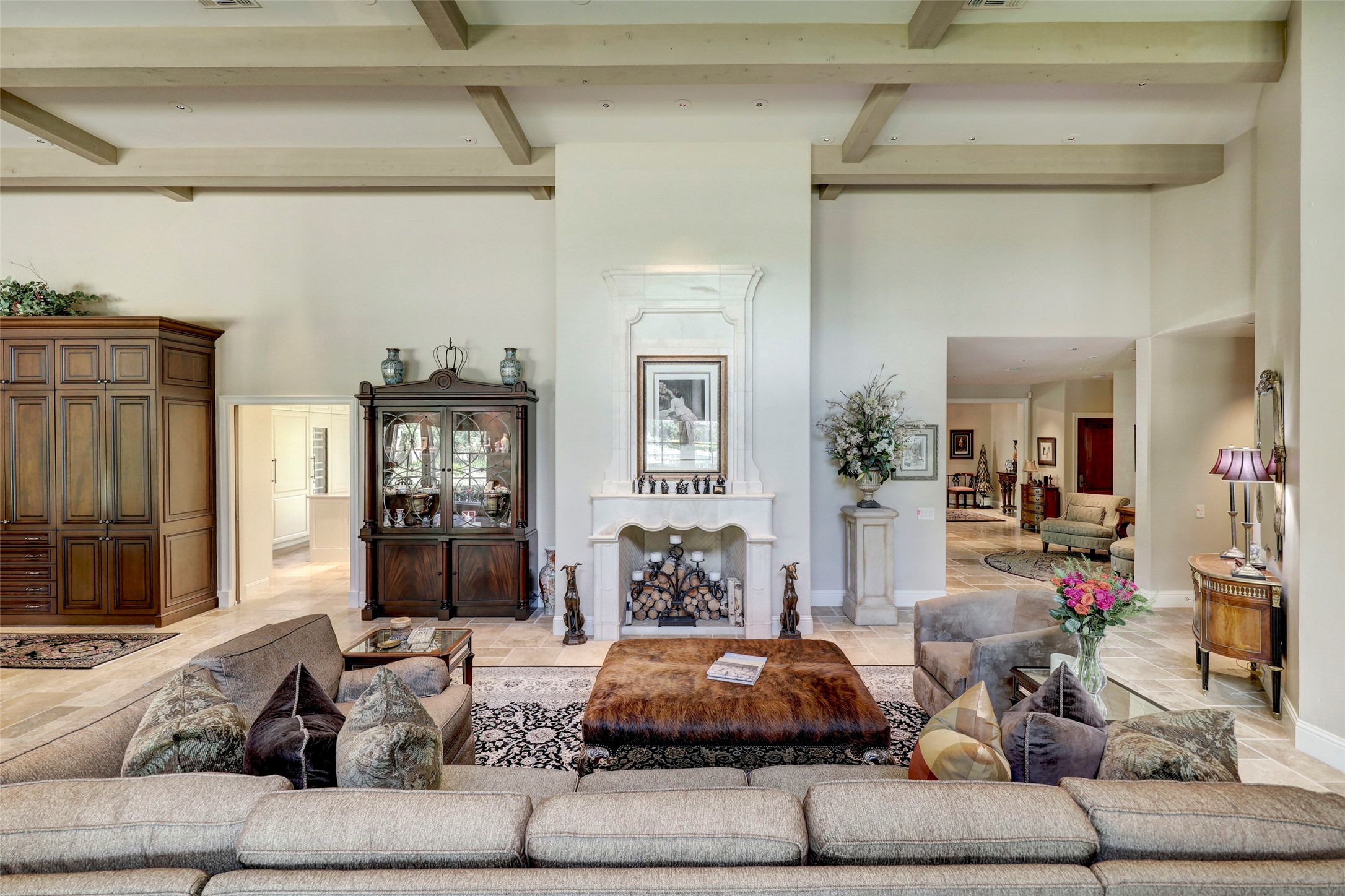 The family room has plenty of room for seating, a stone fireplace and soaring beamed ceiling.