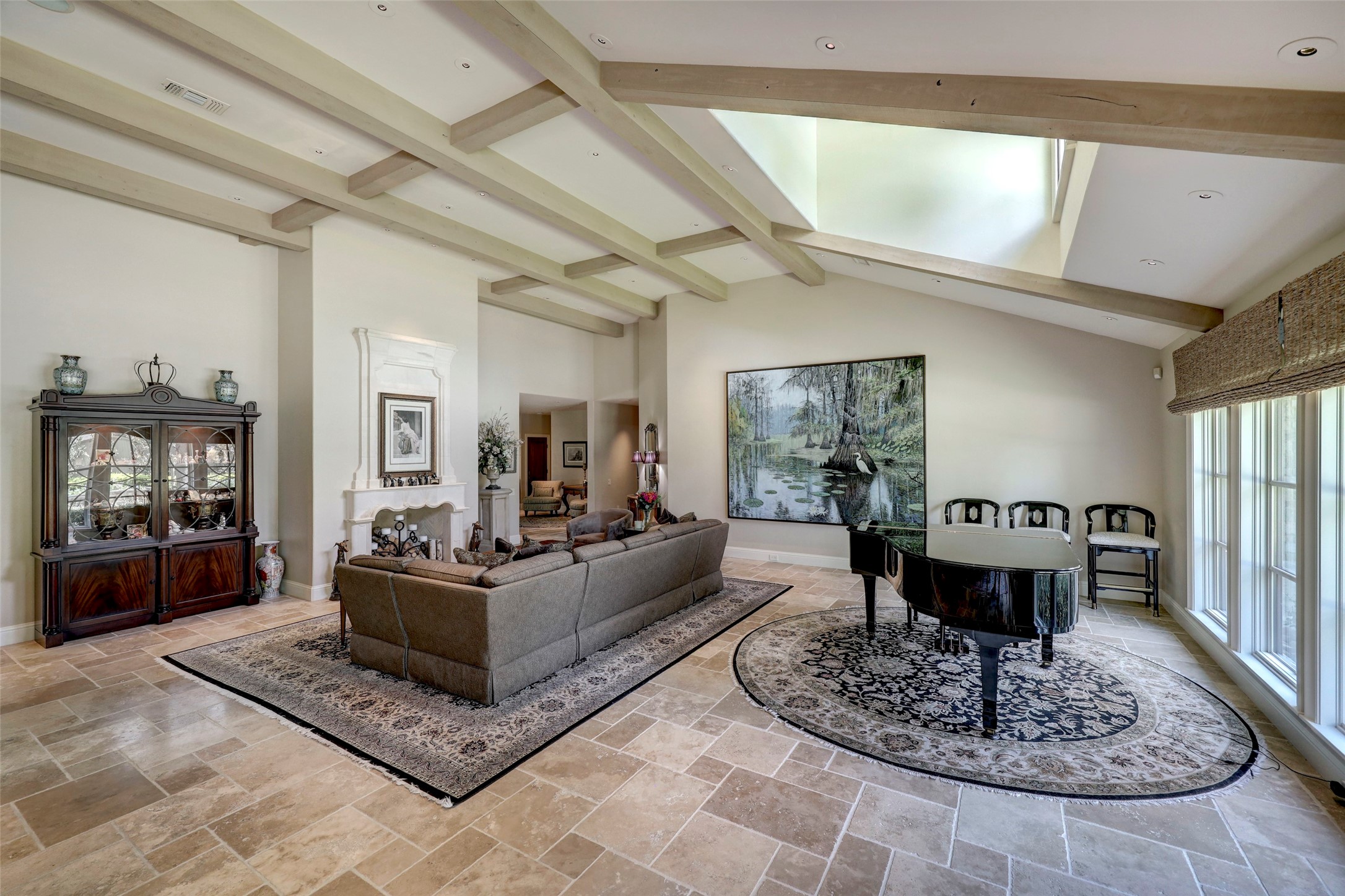 The great room features stone floor, high ceiling and abundant natural light.