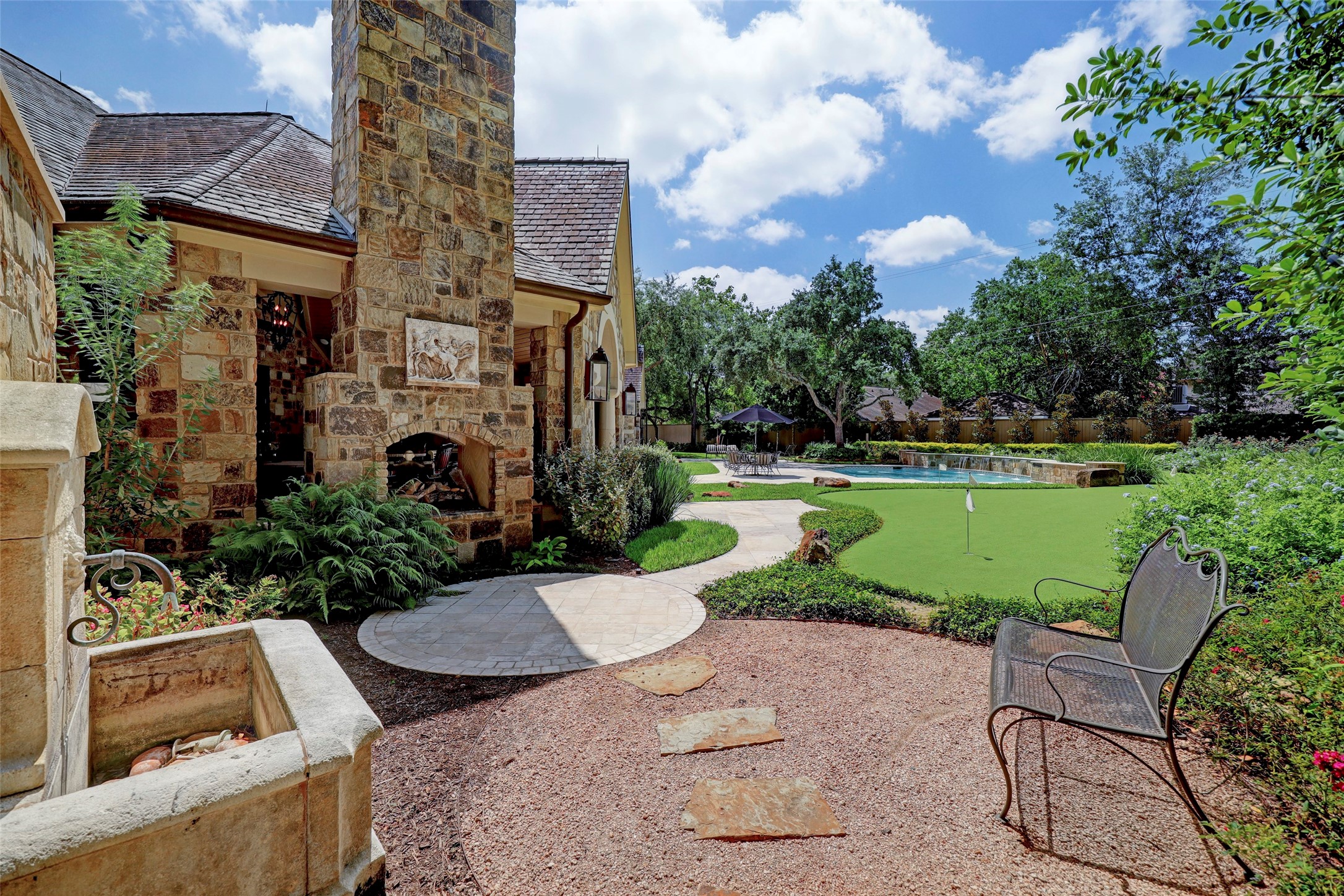 The backyard is a retreat with multiple gathering spaces including this one with a water feature and fireplace.