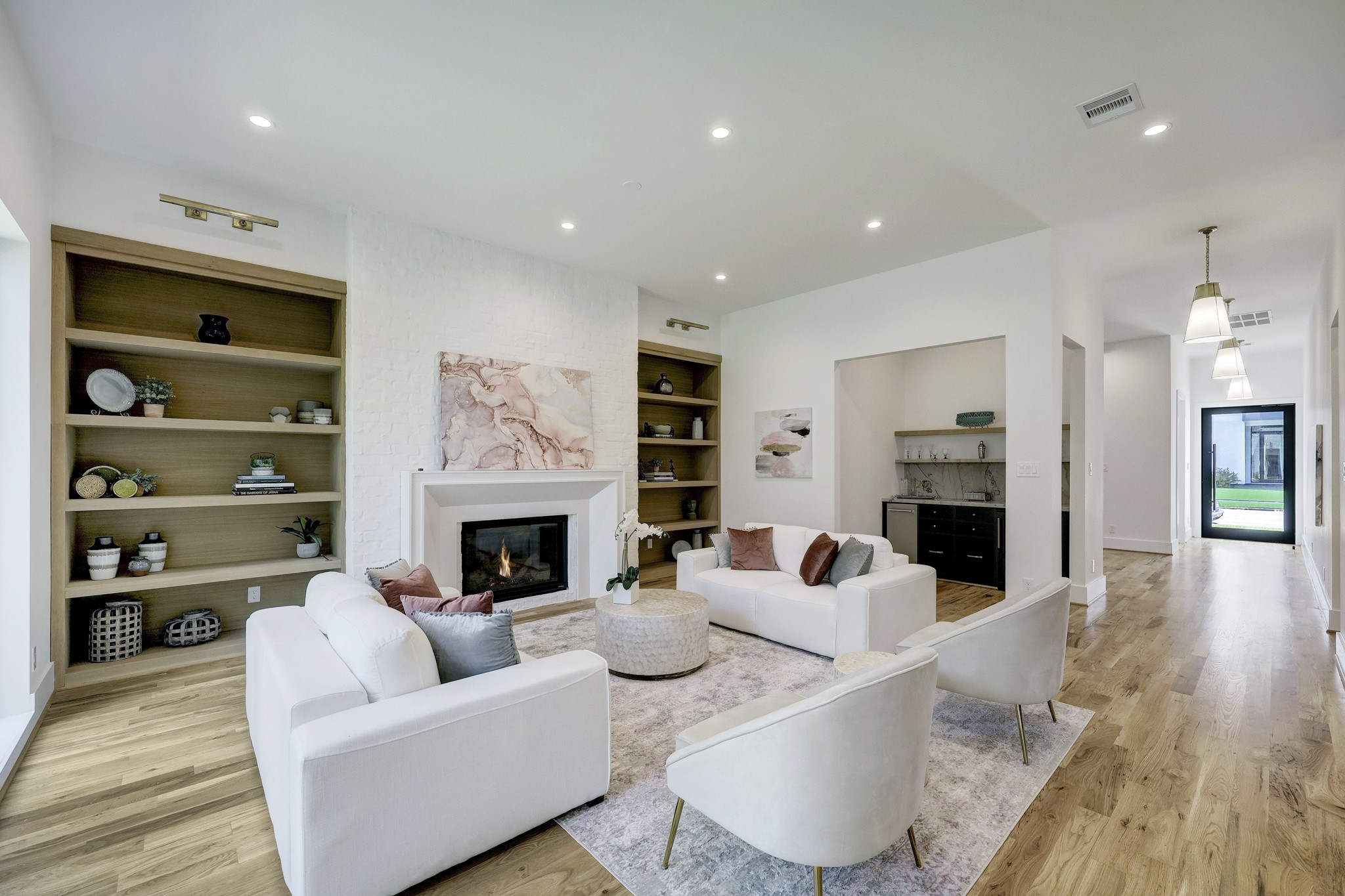 Great room with 11 ft. ceilings, fireplace, and wall of 8 ft. windows for natural light highlighted by wine room and dry bar with ice maker and beverage refrigerator