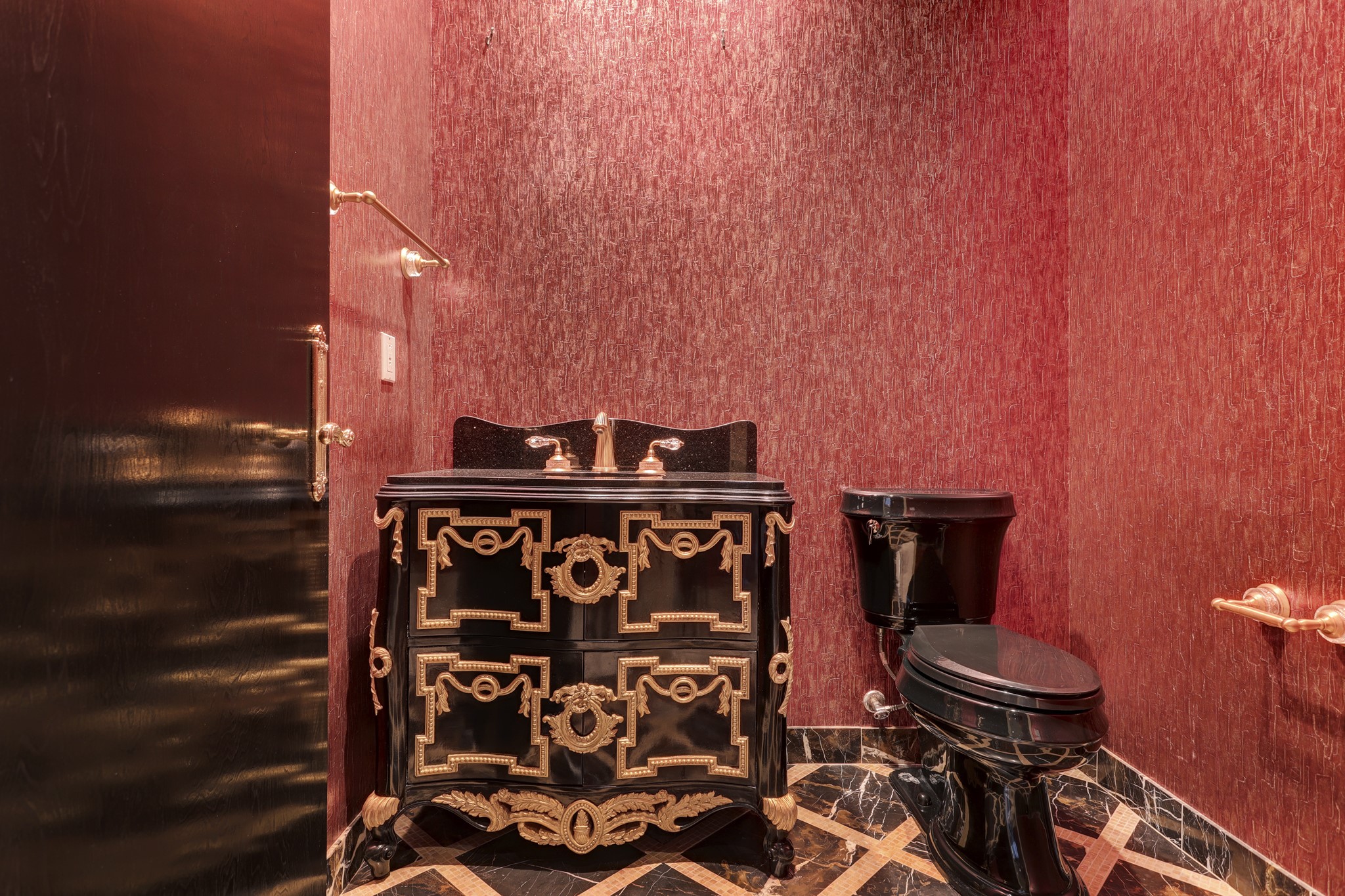 The Powder Room features custom wallpaper, Sherle Wagner fixtures, custom built furniture-style vanity and marble floors with decorative inlay.