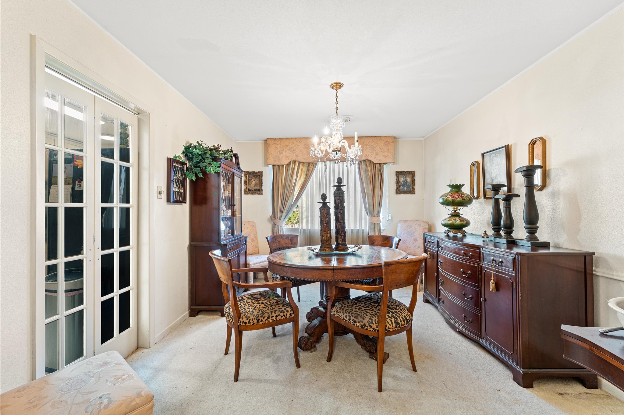 Formal dining room has tasteful vintage chandelier. The dining room is in-between the kitchen and primary bedroom.