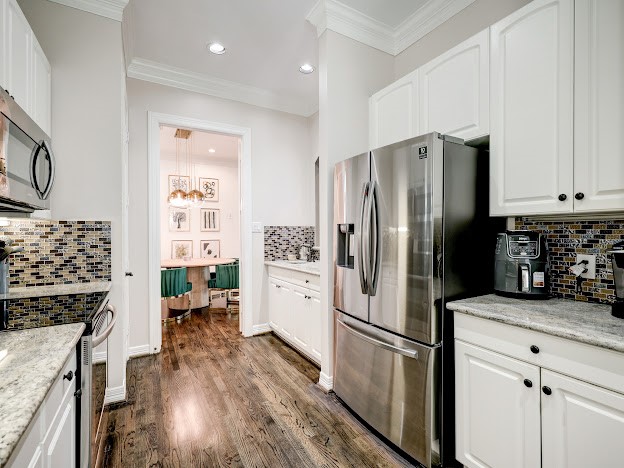 Stainless steel appliances in the updated kitchen. Granite countertops.