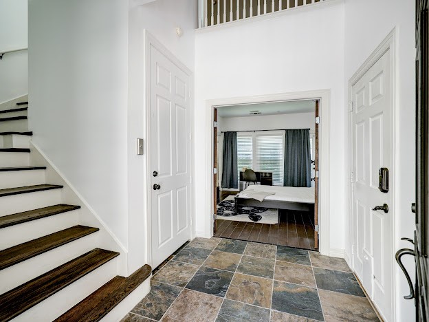Foyer has Travertine tile and access to a primary bedroom.  The door on the left is the elevator.