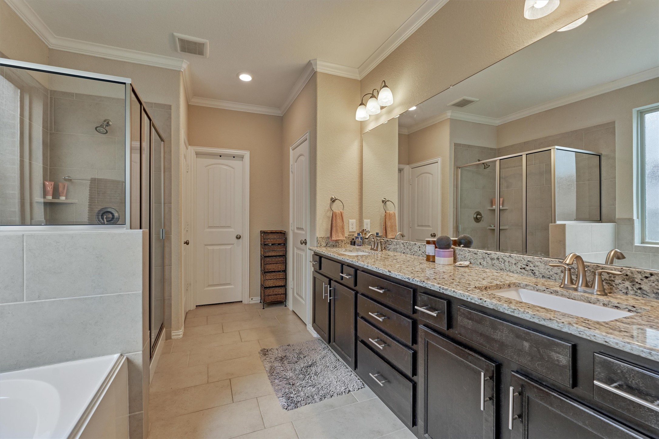 The primary bathroom is very spacious and enjoys neutral colors, ceramic tile flooring, and a large walk-in closet.