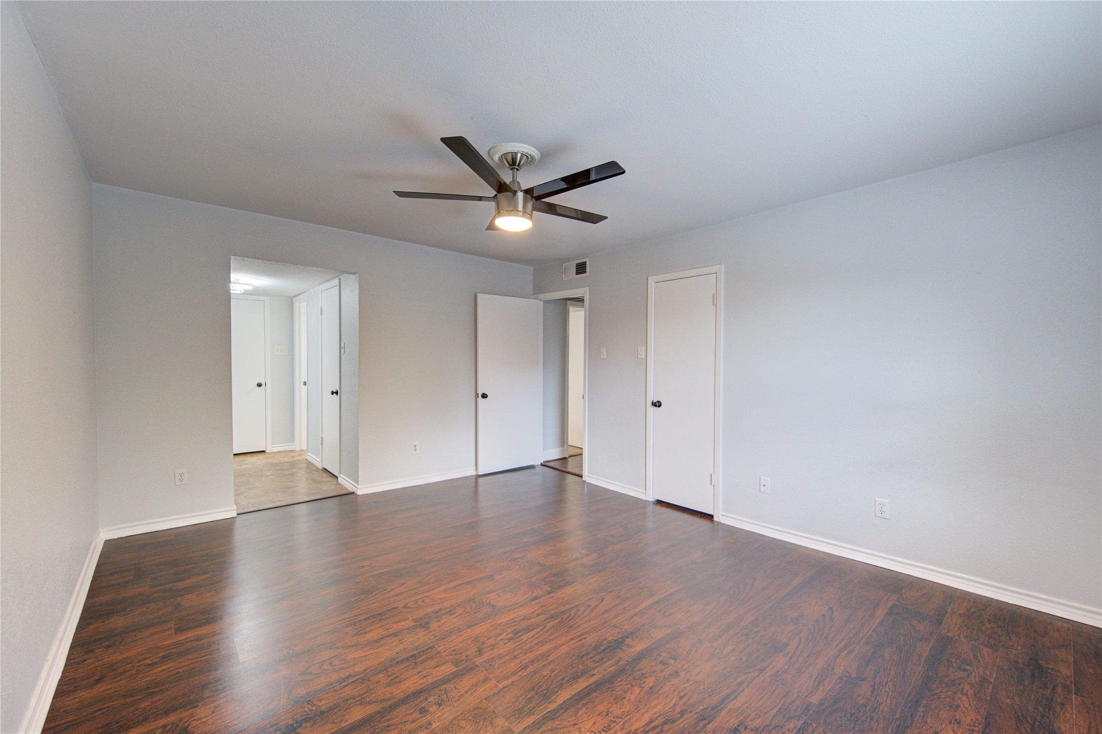 At the end of the hall you'll find this bright & spacious primary bedroom that features two walk-in closets and a new sleek ceiling fan.