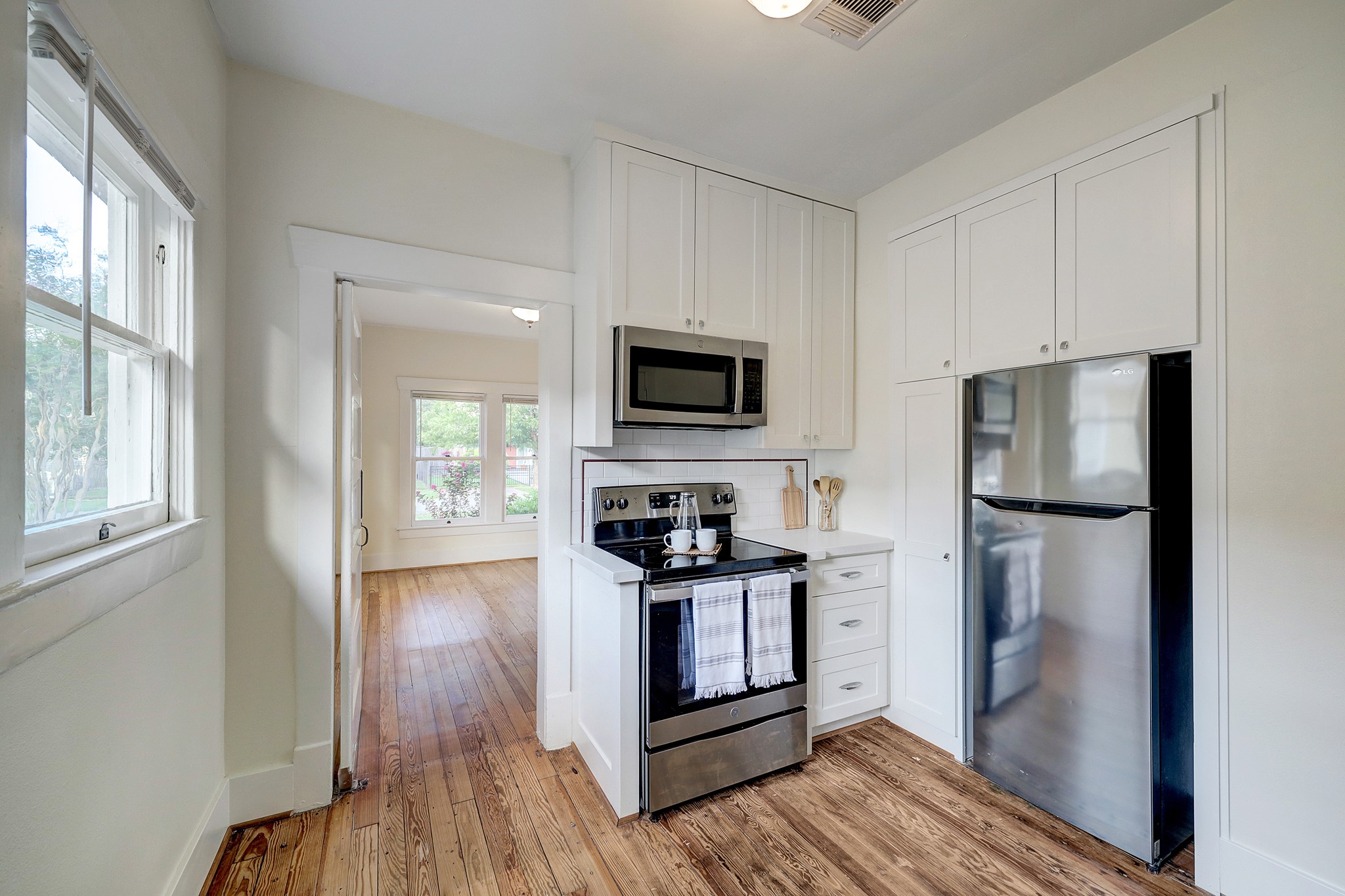 Original kitchen painstakingly restored with modern upgrades, floor to ceiling built in cabinets with shaker style custom pine facing, white granite countertops, stainless steel appliances, note period pencil tile on backsplash.