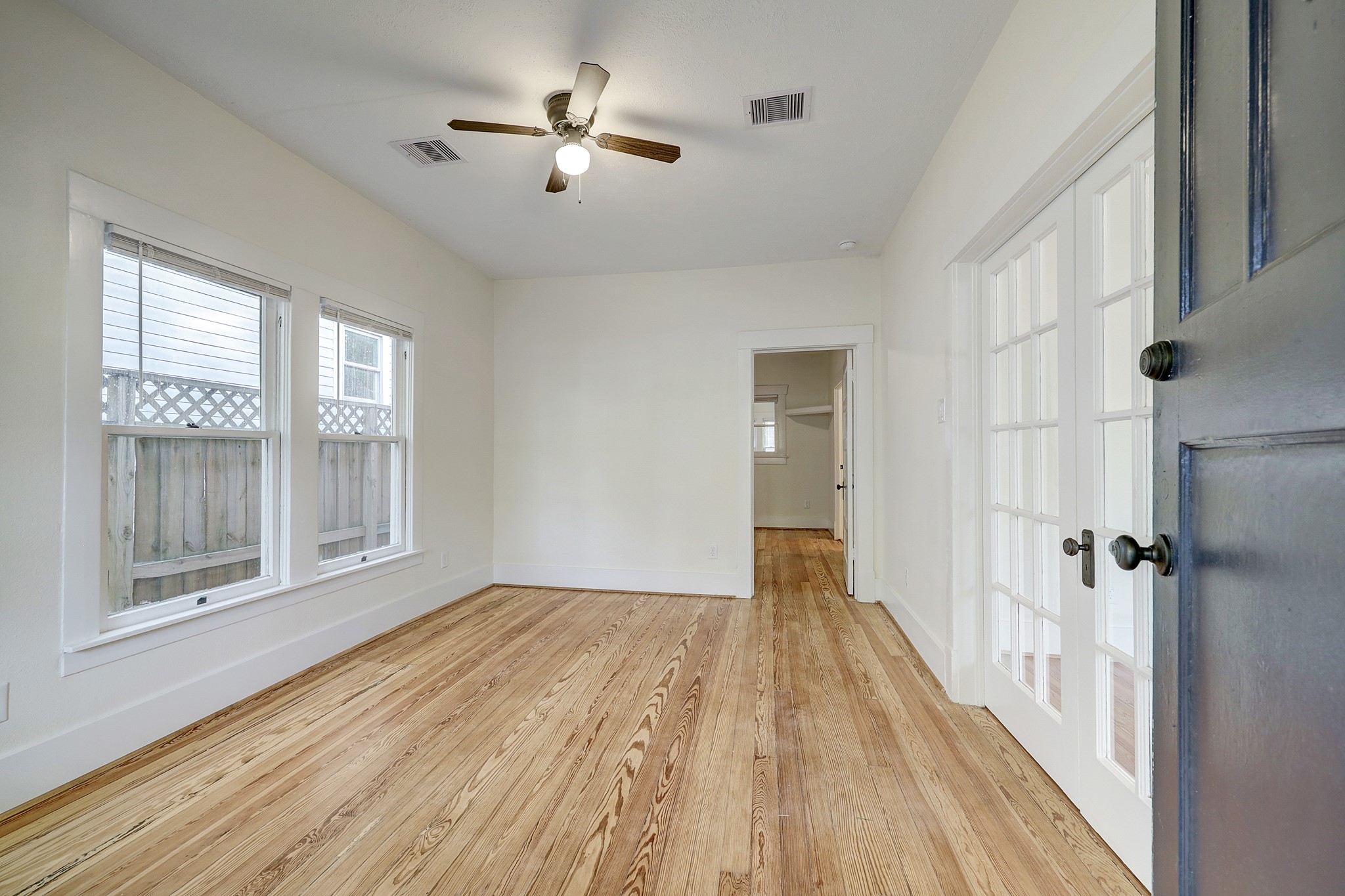 Completely restored original long leaf pine floors throughout house.  Note the antique French doors separating the living and dining spaces.