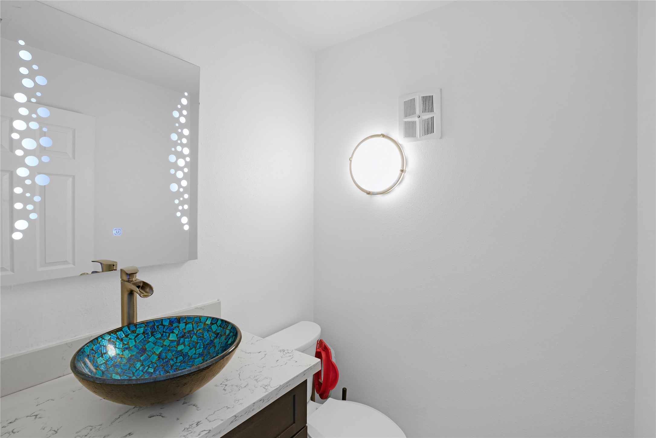 Half bath off the entry with smart mirror and vessel sink.