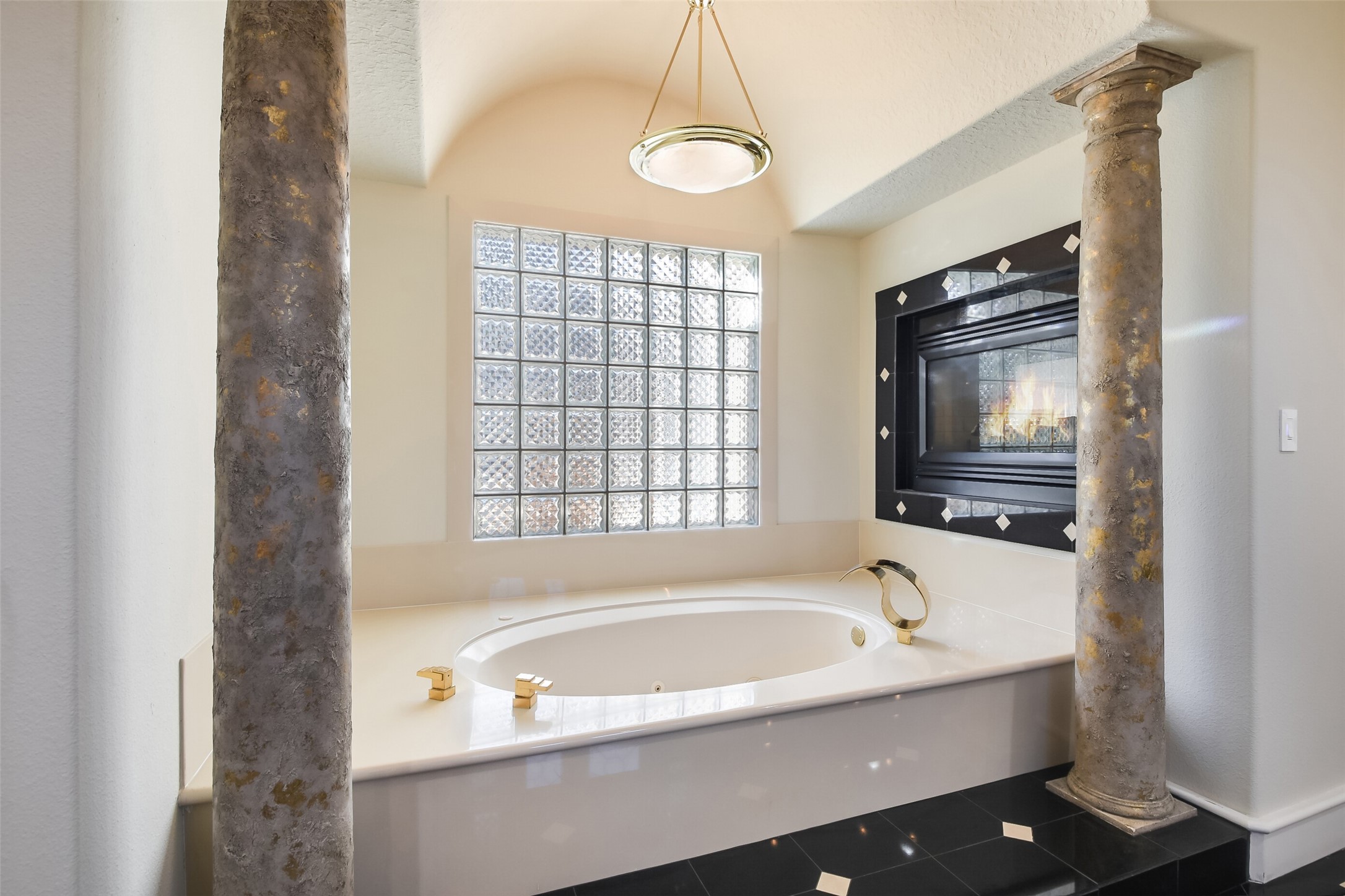 Relax in your jetted tub with elegant fixtures and view of the fireplace!