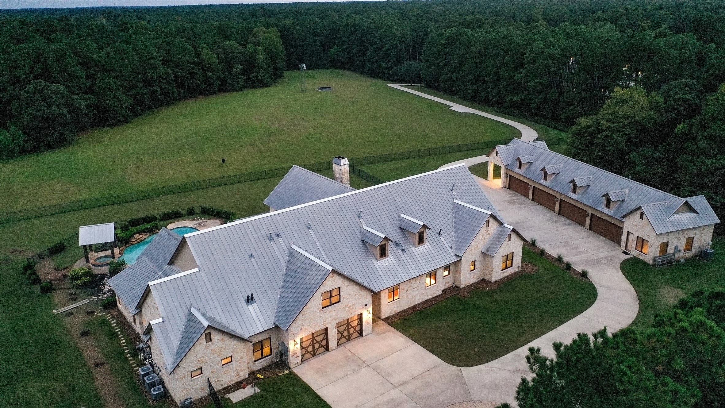 This 1.5 story sprawling house is 7870 sq. ft is located on 38.86 +/- private acres.  This view is of the back of the house.Plenty of parking for your guests at this house.