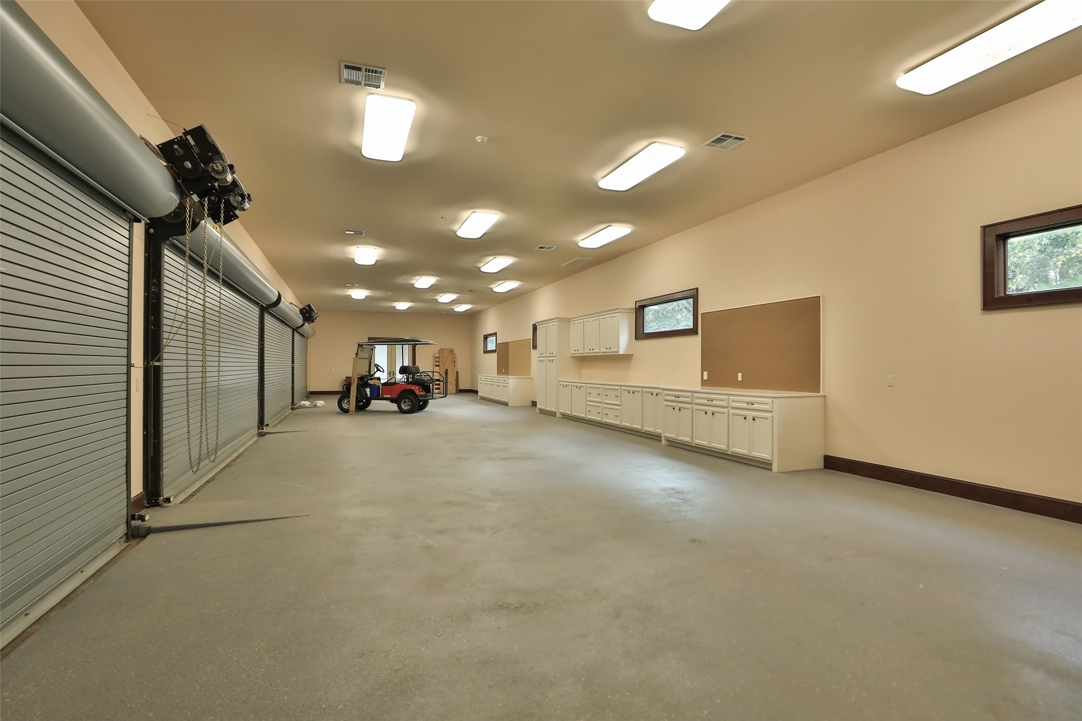 This extraordinary 8 car epoxy garage is A/C and heated. Heavy duty garage doors and plenty of lighting is featured. Built-ins for your workshop.