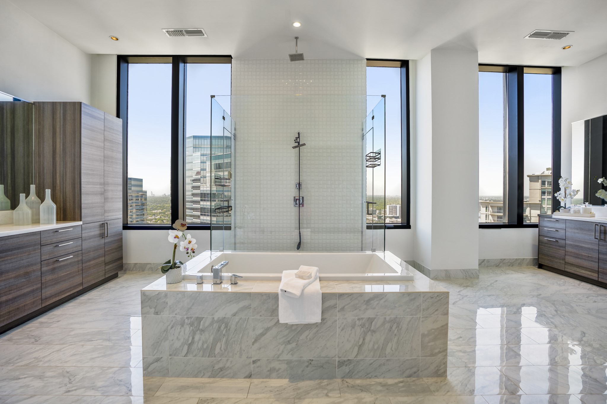 This primary bathroom features
a walk-in shower with tile
surround, separate tub for
soaking after a long day, light
countertops, tile floors, and
sleek modern finishes!