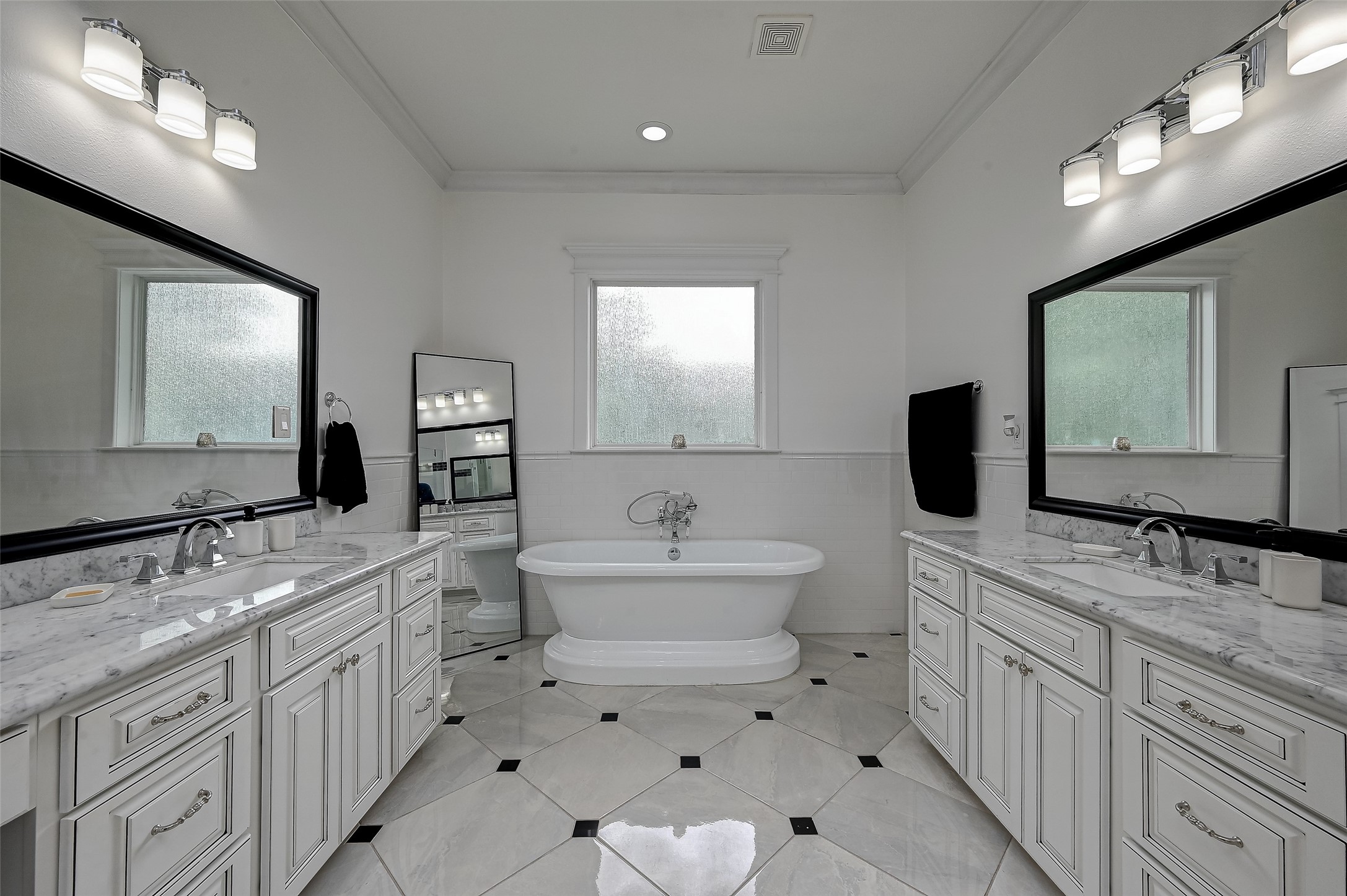 Indulge in the spa-like retreat of the primary bathroom, where a stunning soaking tub takes center stage, inviting relaxation amid its elegant surroundings.