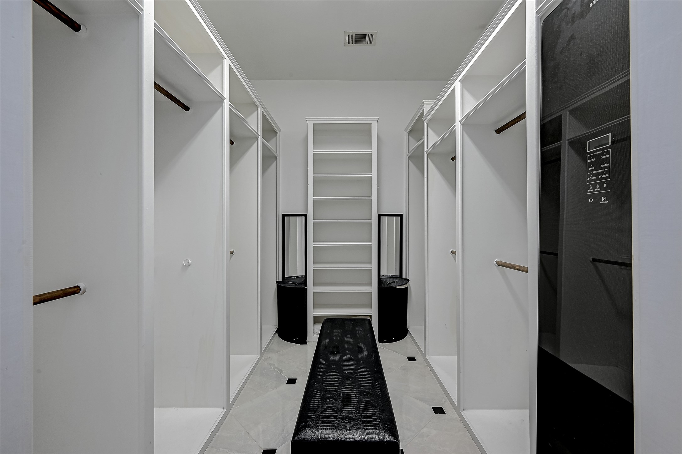 Step into the realm of organizational luxury within this dream walk-in closet, where a carefully crafted space features multiple hanging rods that elegantly display your wardrobe. Built-in shelving showcases accessories and shoes, turning them into pieces of art while maintaining easy access.