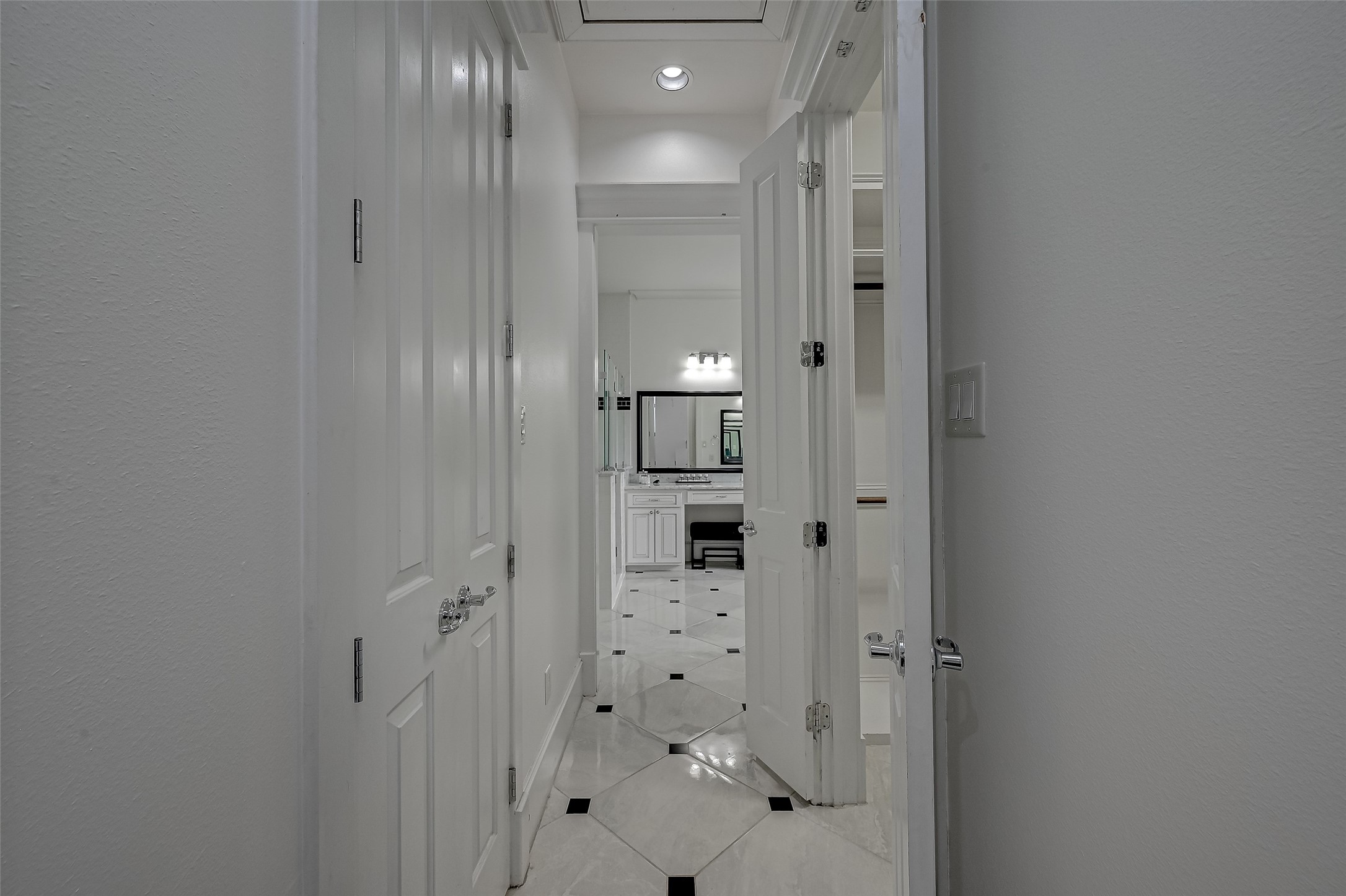 The hallway gracefully guides the way towards the spa-like bathroom, flanked by dual closets on each side, seamlessly blending practicality and aesthetics.