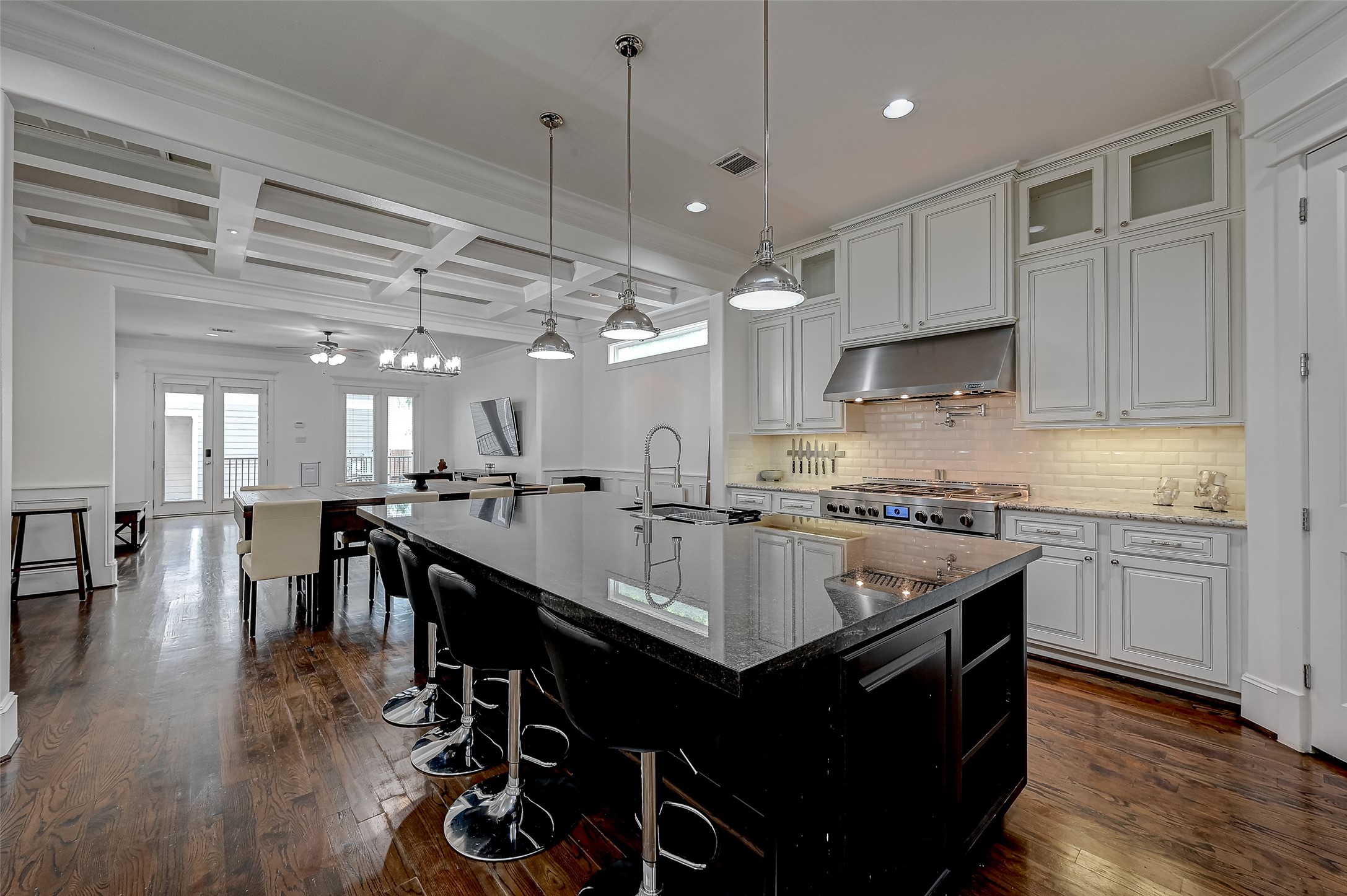 Step into the culinary masterpiece that is this kitchen, where a sprawling center island takes center stage, surrounded by sleek granite countertops that exude both luxury and functionality.