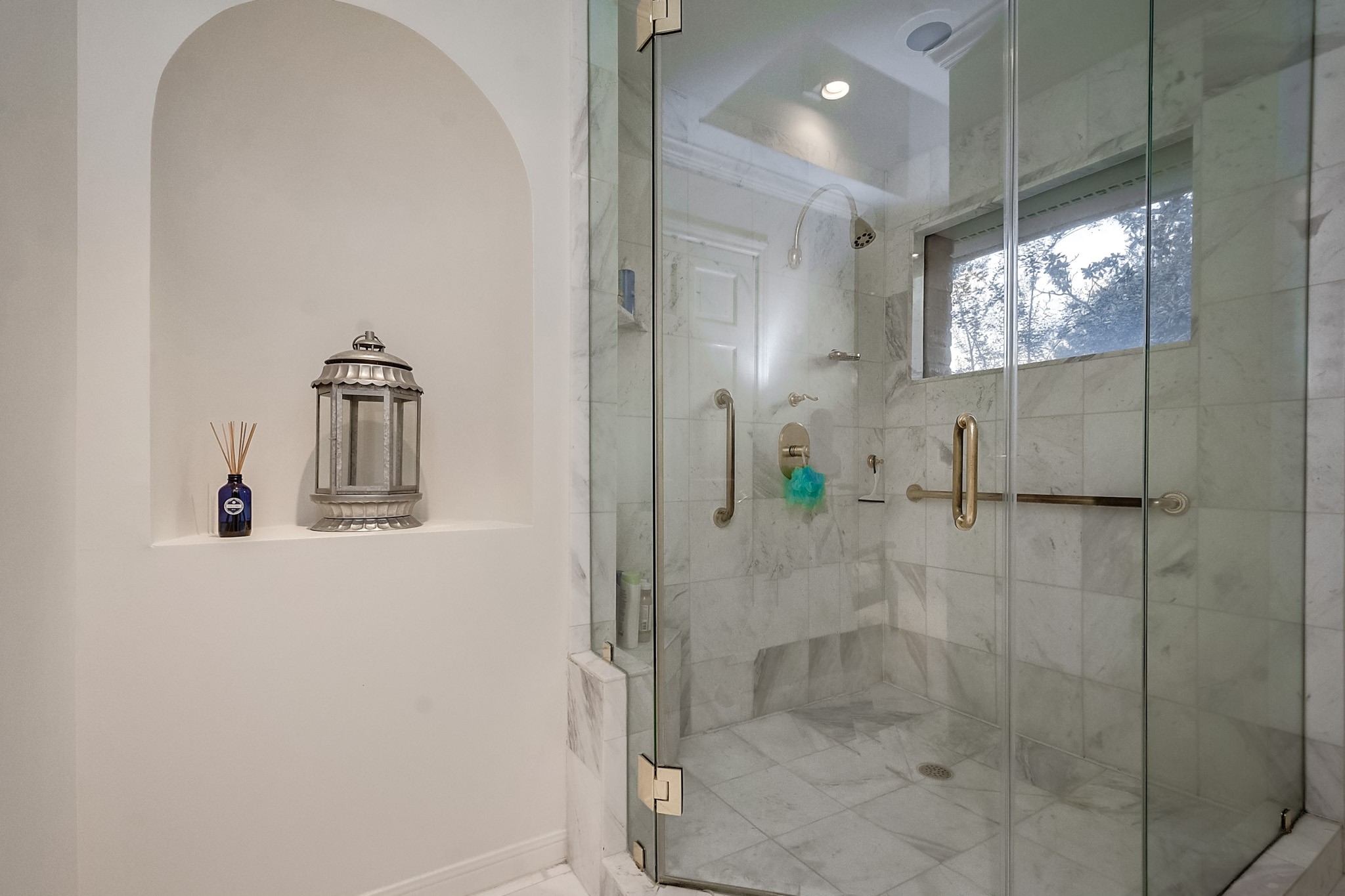 Huge walk-in marble shower with natural light.