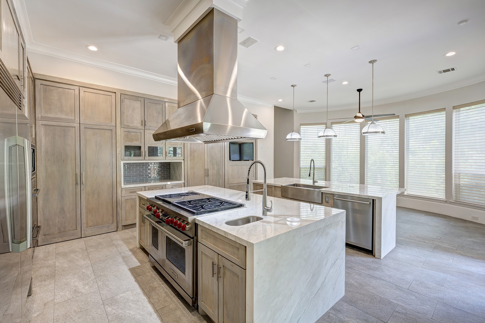 Gourmet kitchen includes two oversized islands, custom cabinets, three ovens, warming drawer, Wolf gas cooktop & grill and Electrolux Refrigerator & Freezer.