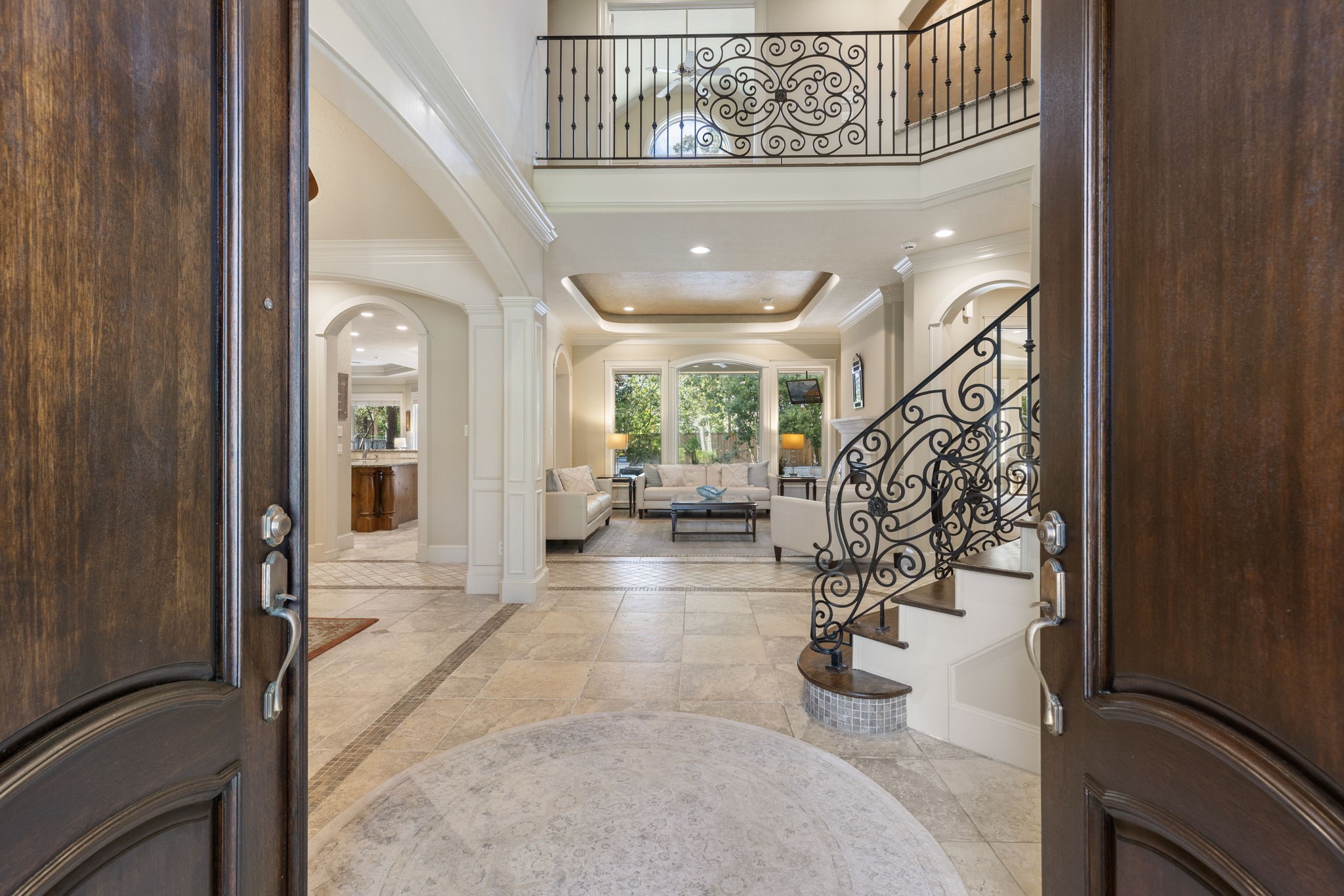 Enter this exquisite home through double solid wood doors to an inviting foyer with soaring ceilings, tile flooring with decorative border, spiral staircase and a glimpse of the beautiful outdoors.