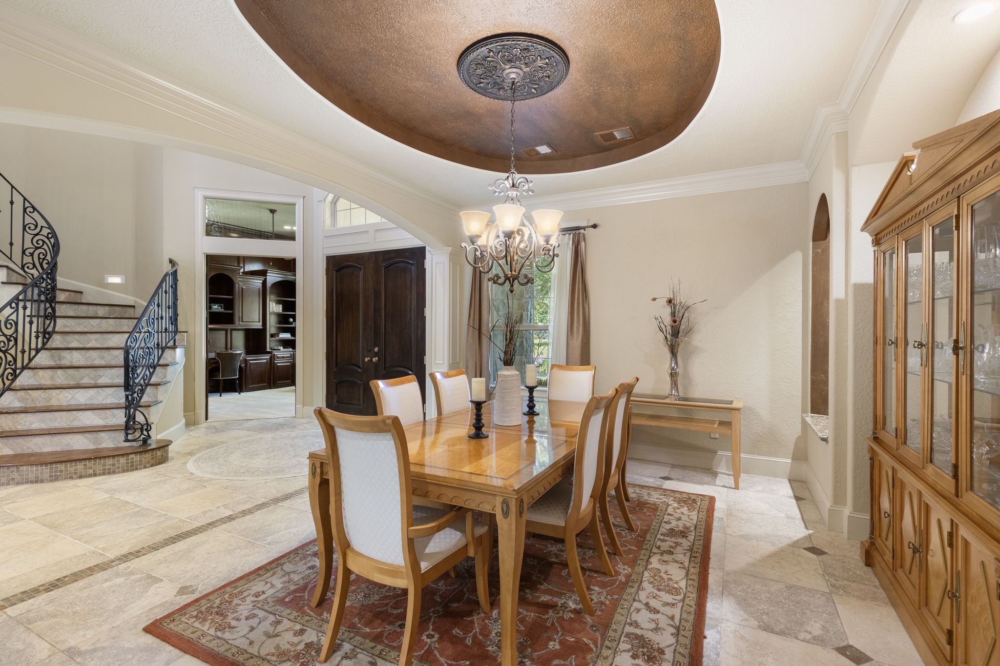 The elegant dining room offers a large space for entertaining with decorative niches, timeless tray ceiling and classic crown moulding.