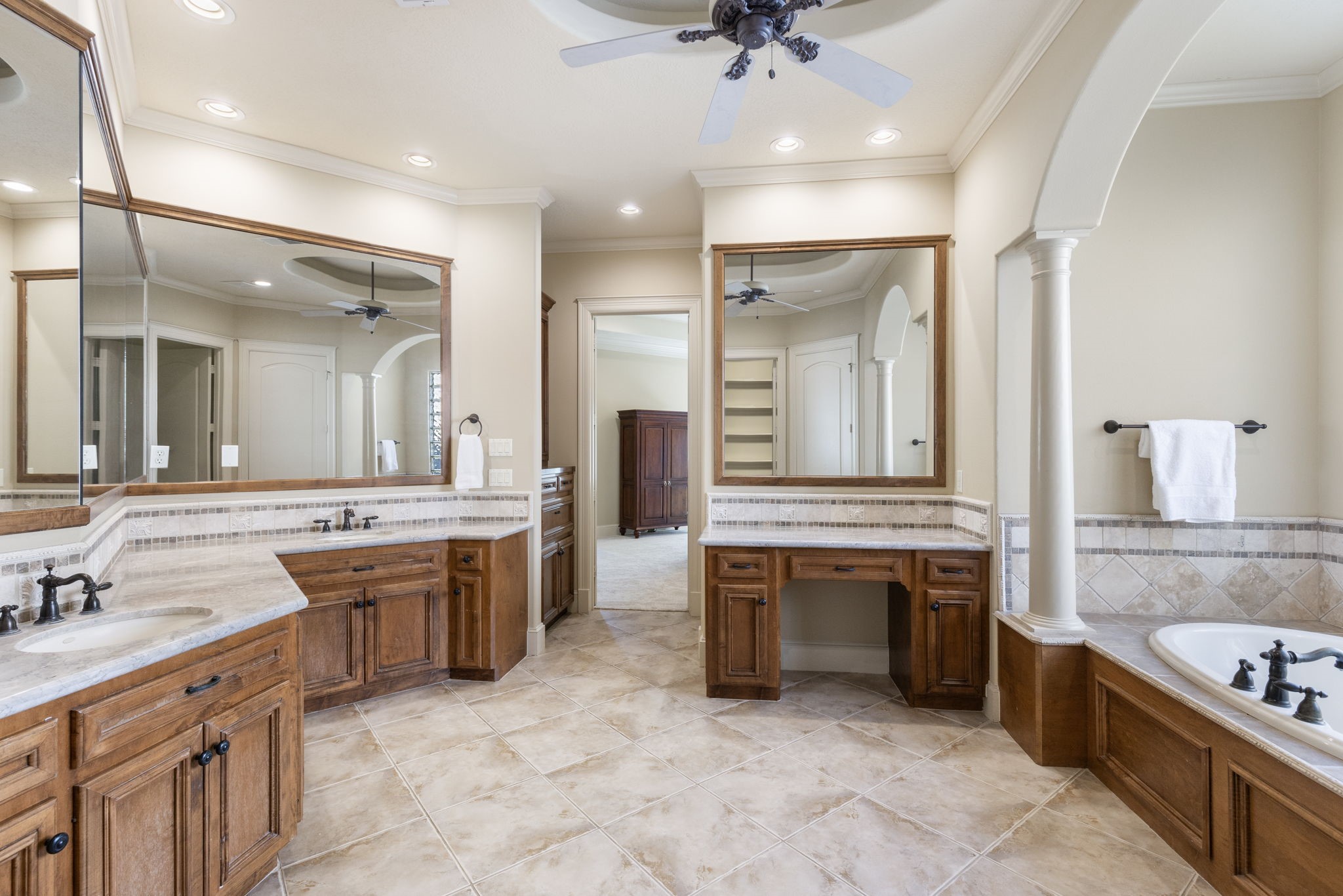 The primary ensuite bathroom features a jetted soaking tub, separate shower, large vanity area with double Kohler sinks, custom cabinetry with a built-in linen storage, LUXE bidet and huge 