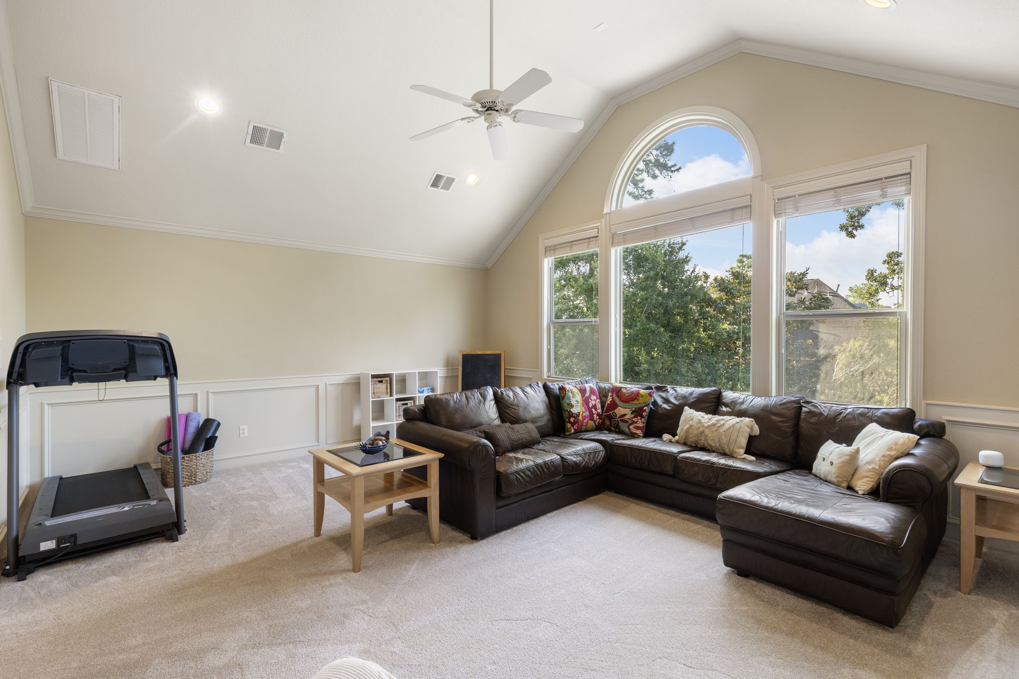 The cozy game room also has a vaulted ceiling with large wall of windows allowing for lots of natural light, neutral paint, crown moulding and wainscoting.