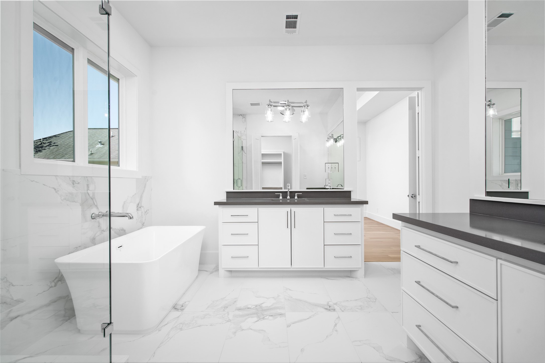 The primary bath features custom cabinetry, dual vanities, large soaking tub and stunning porcelain flooring.