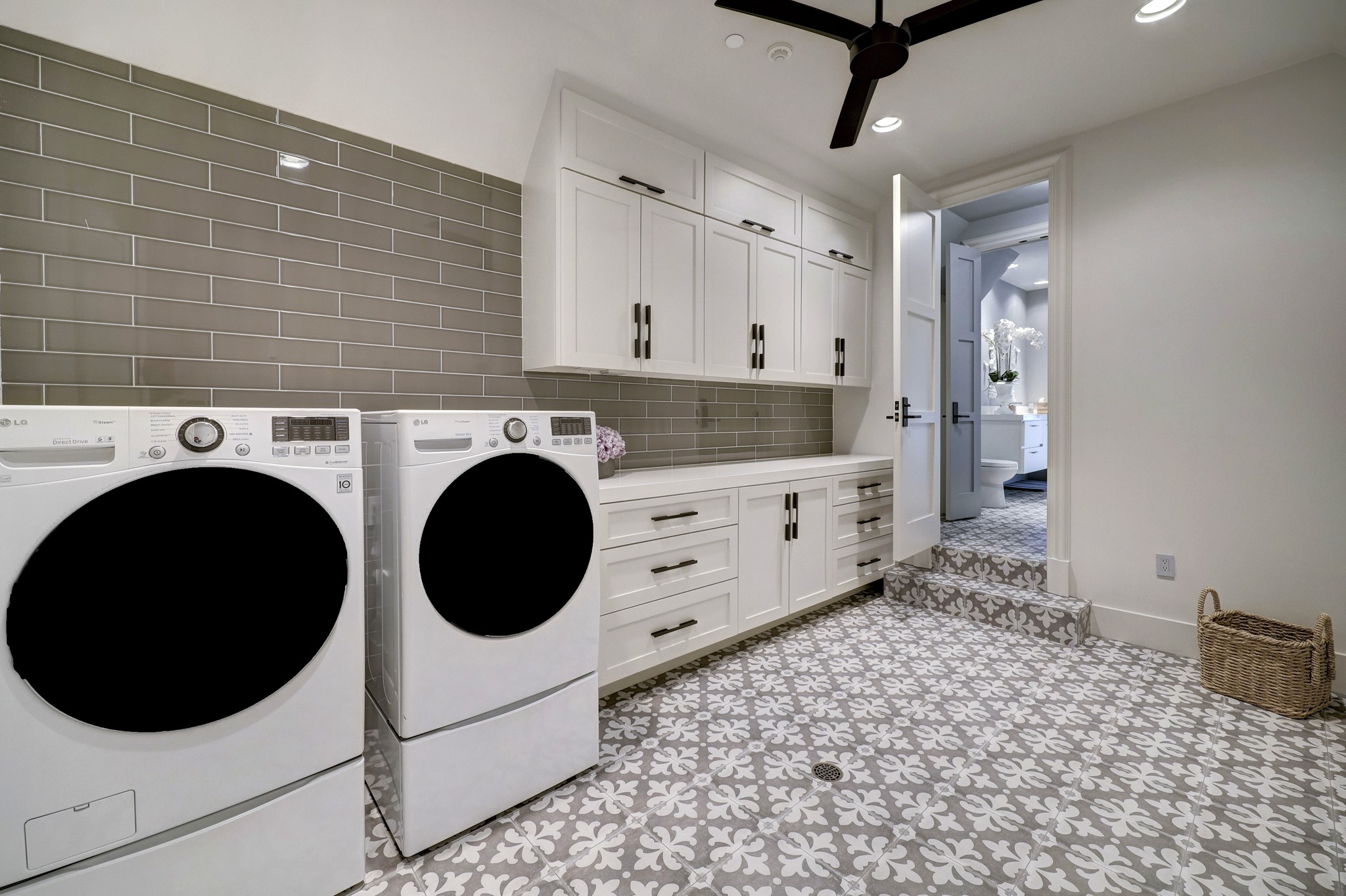 A secondary utility room leads you to the guest quarters of the home, one of the multiple ways to access the guest quarters. Utility room has an LG washer and dryer and custom built in cabinetry for storage.