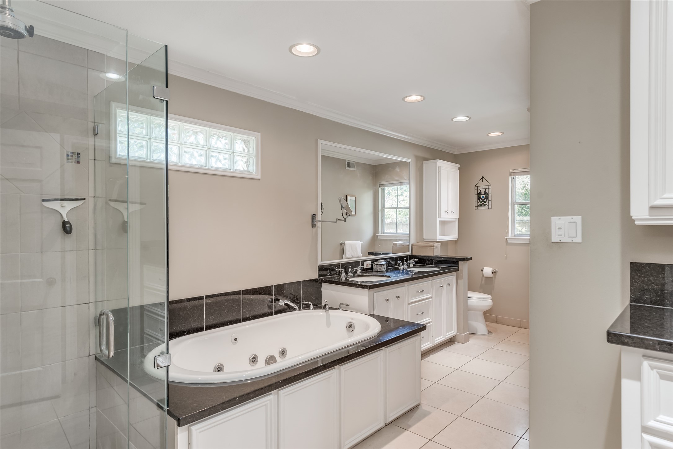Primary bathroom with jet tub, walk-in shower and double sinks.