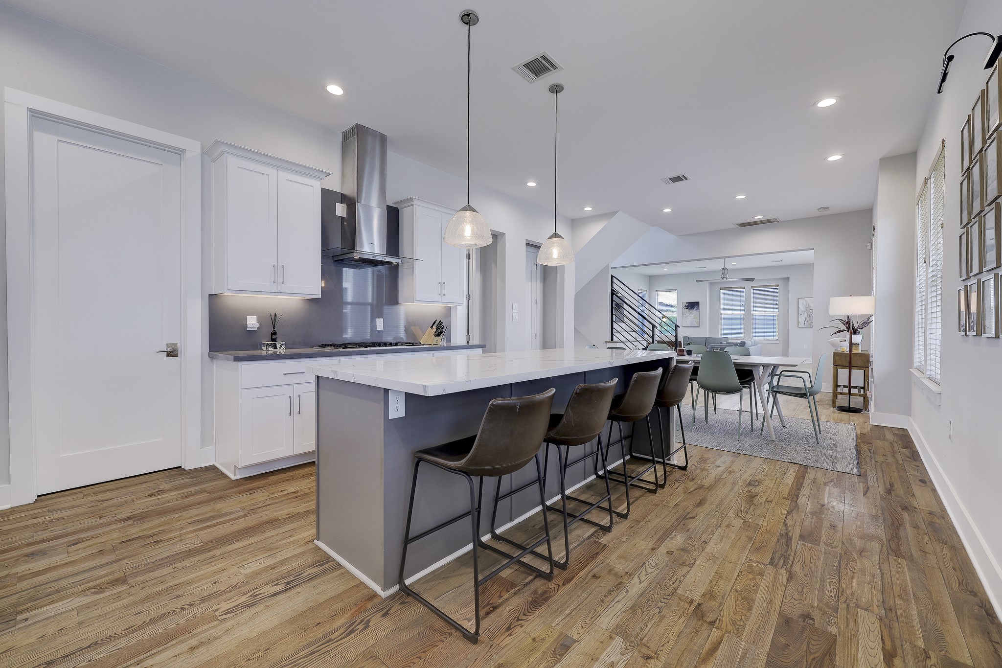 The spacious kitchen island, featuring a stunning waterfall edge design, not only provides ample counter space for meal preparation but also adds a touch of modern sophistication to the entire kitchen space.