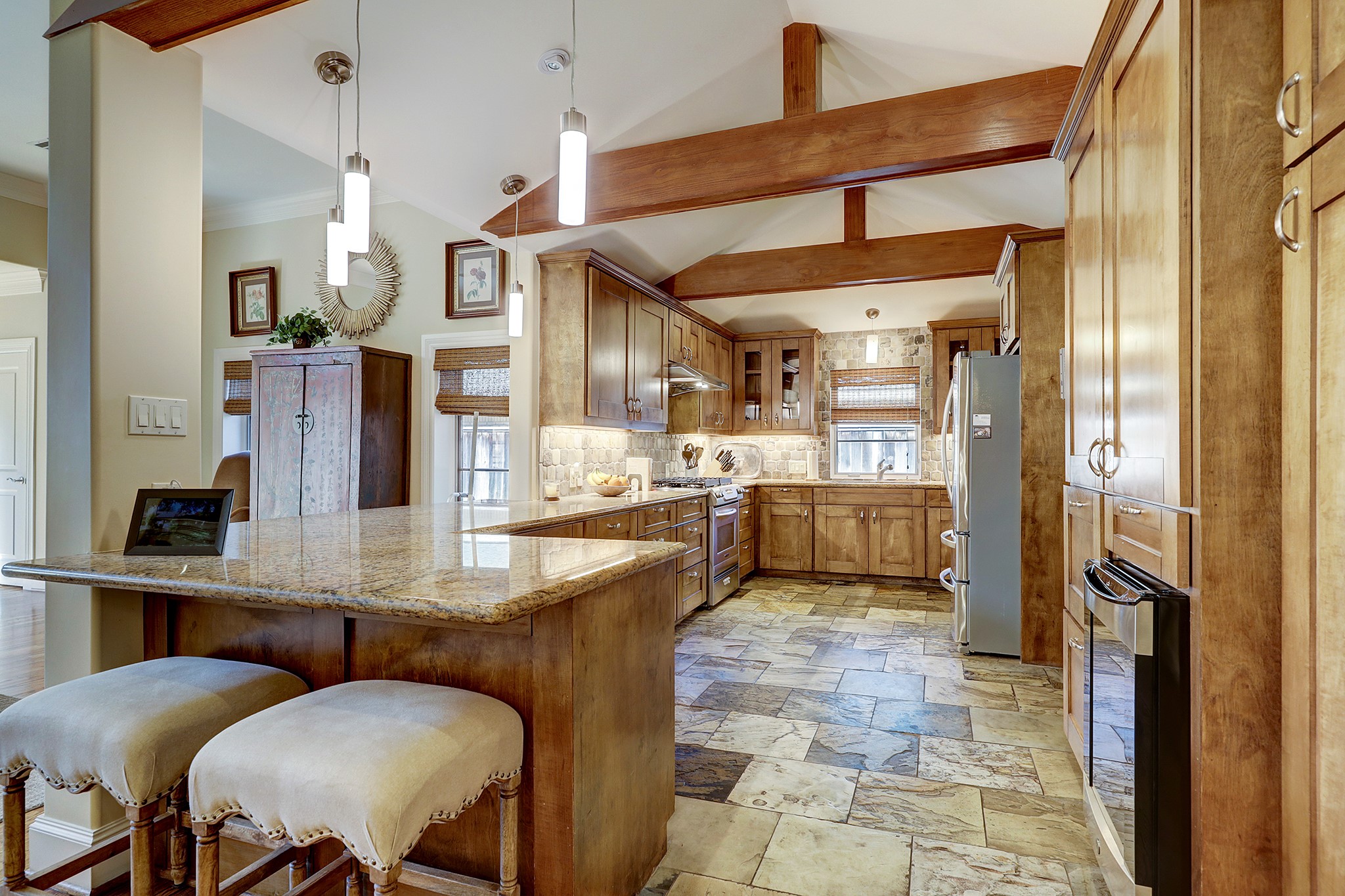 Kitchen opens to Family Room and boasts vaulted ceilings with handsome wooden beams, stainless steel appliances, gas range, granite countertops, and loads of storage!