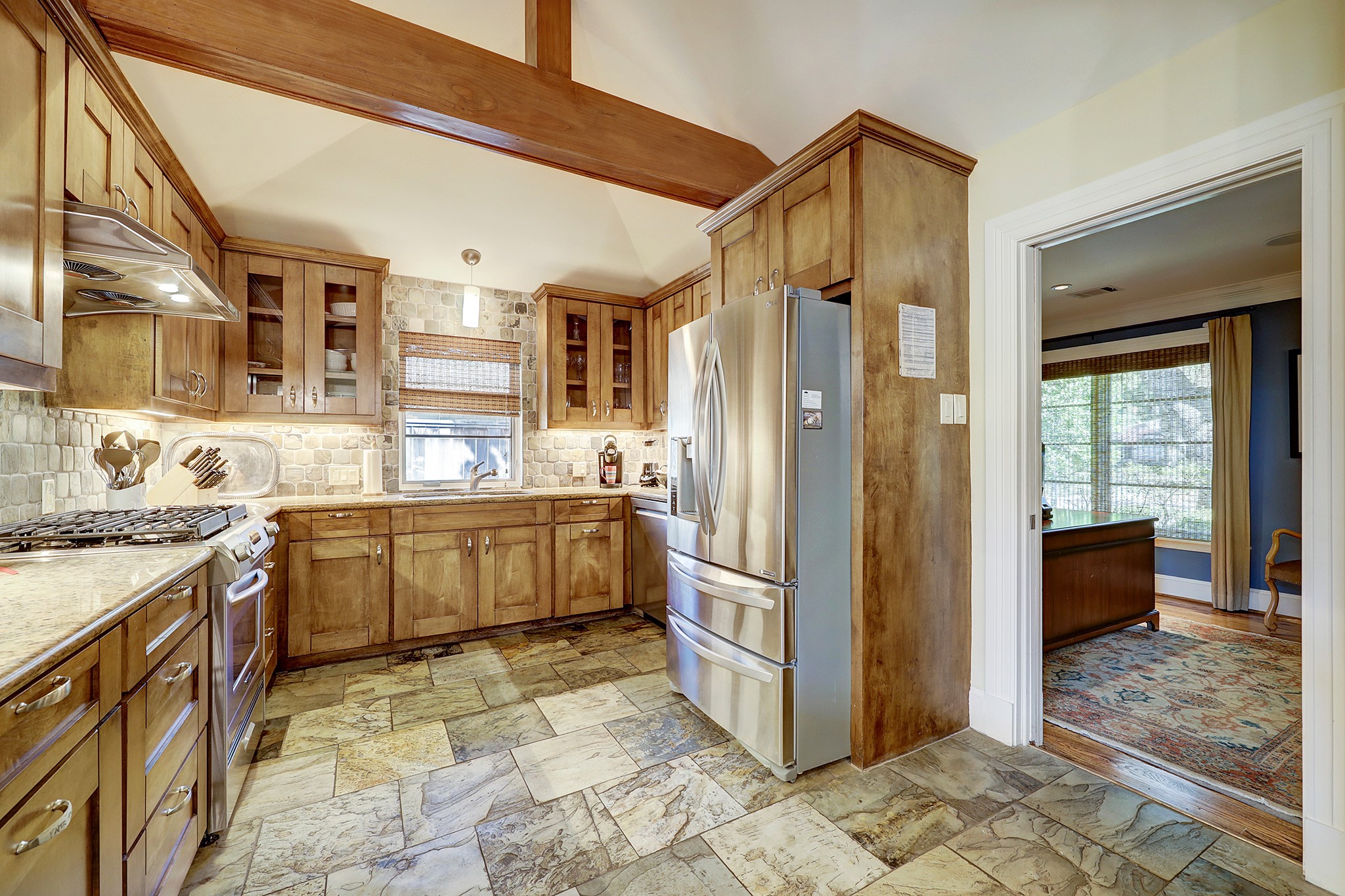 Closer look of Kitchen that showcases the stone backsplash and slate floors.