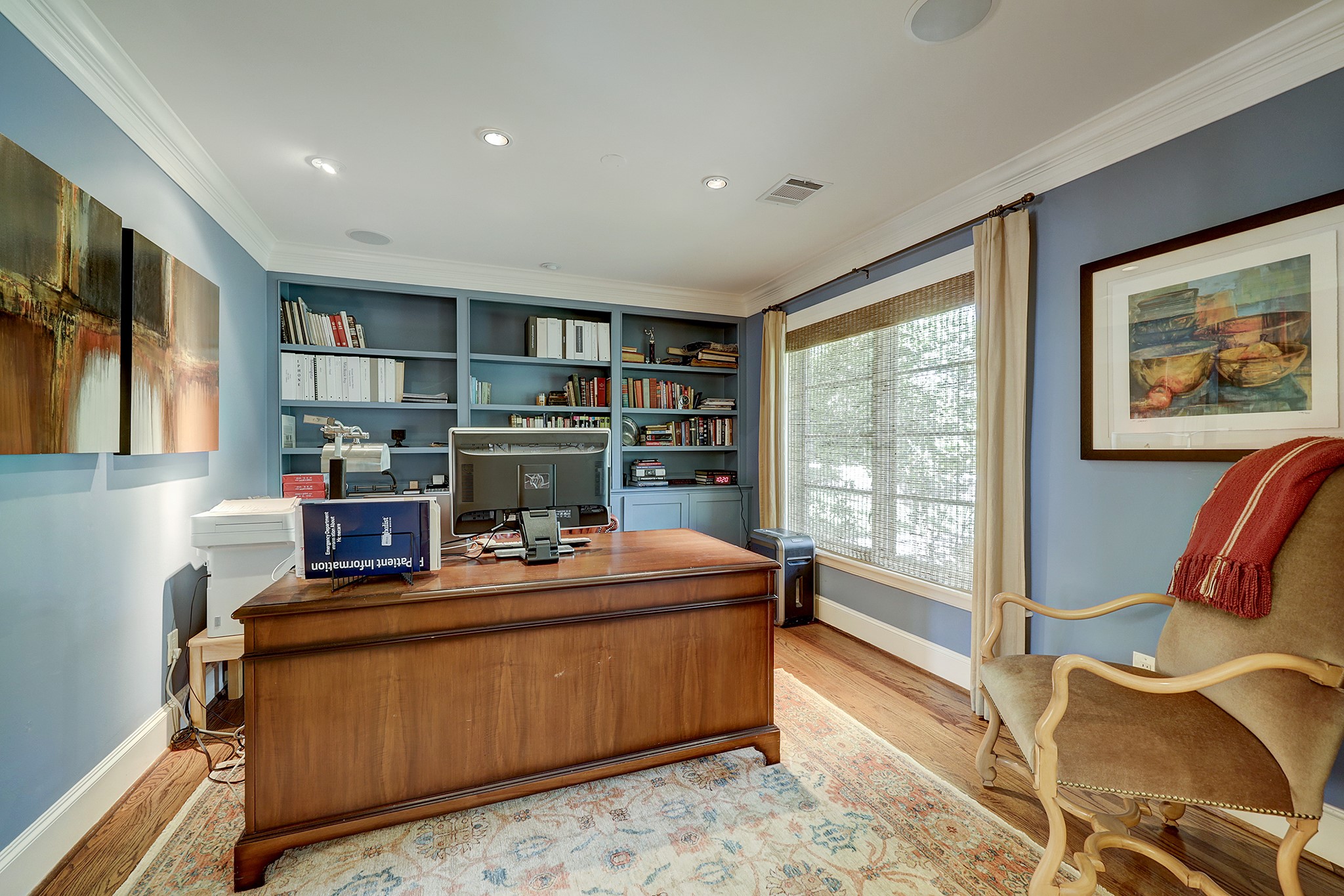 Study with custom built-ins and motorized Provenance Woven Wood Window Treatment by Hunter Douglas.