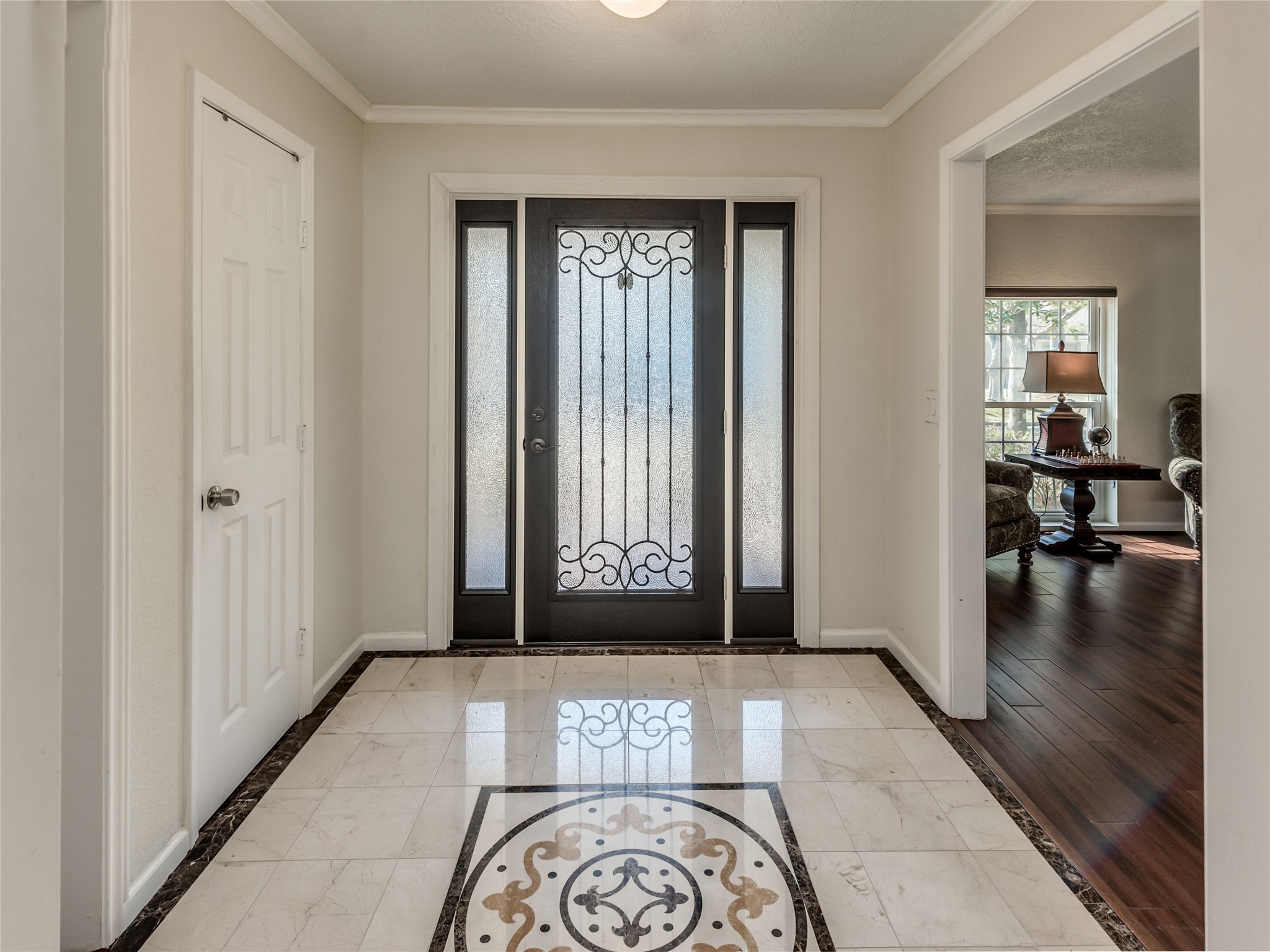 Gorgeous marble tile floors with elegant decorative inlay greet guests as they enter this beautiful home.