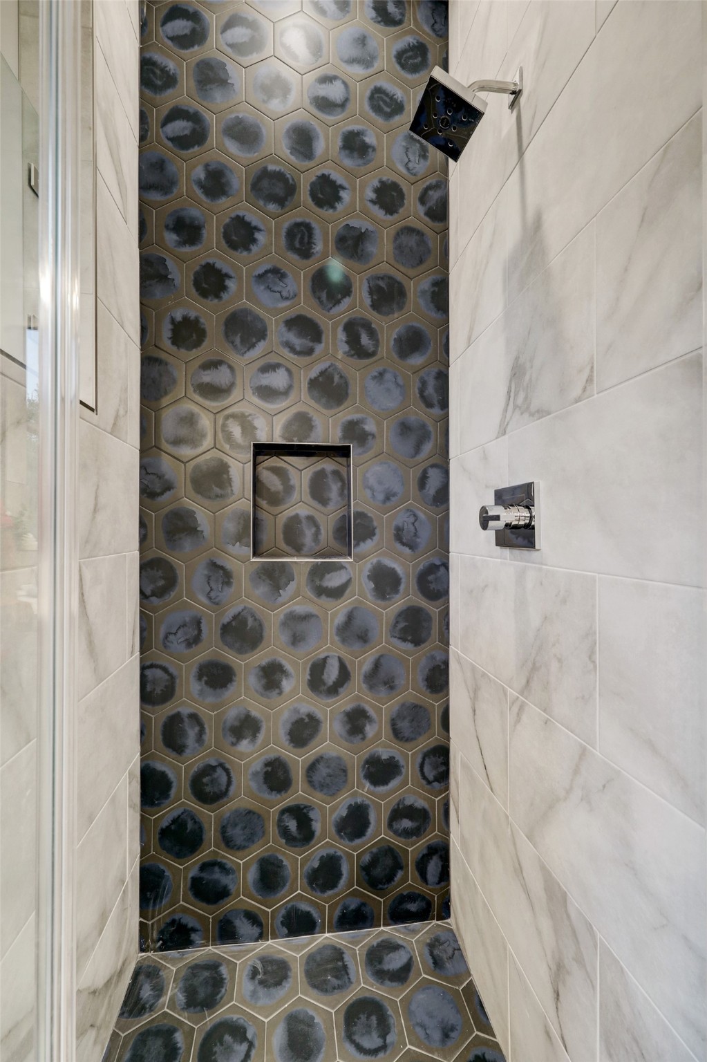 Down stairs walk in shower features gorgeous tile work and design.