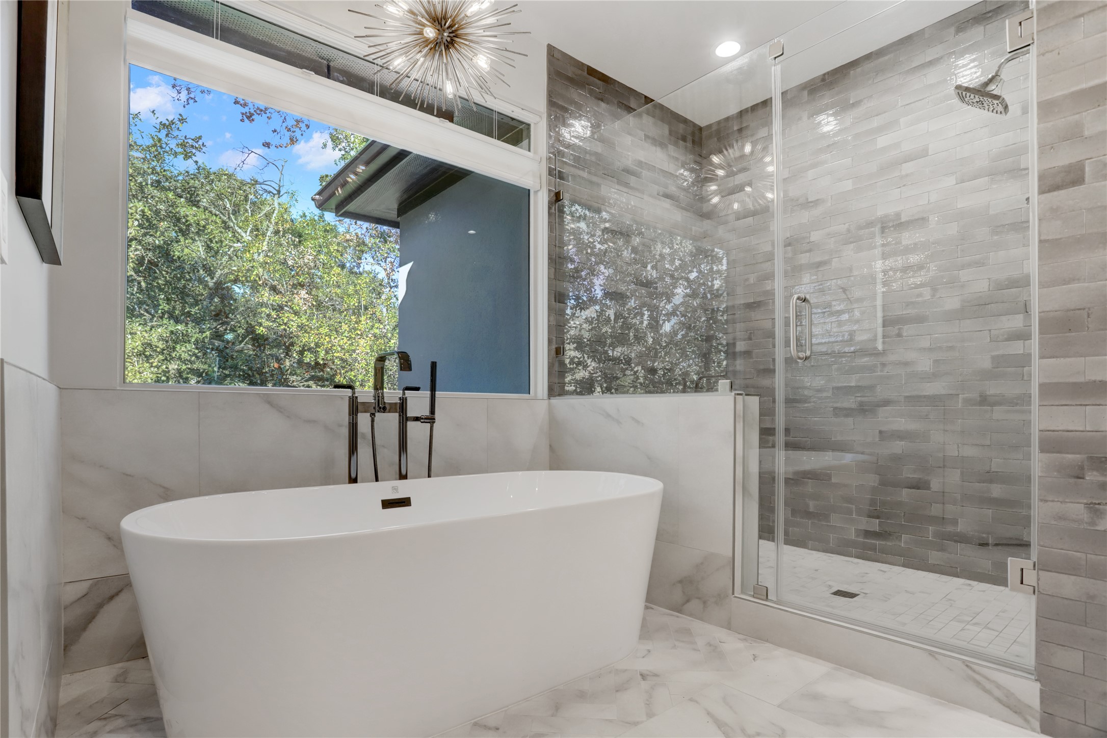 Soak in all the luxury. Floor mounted hardware impressive lighting fixture and tile work creates a statement.