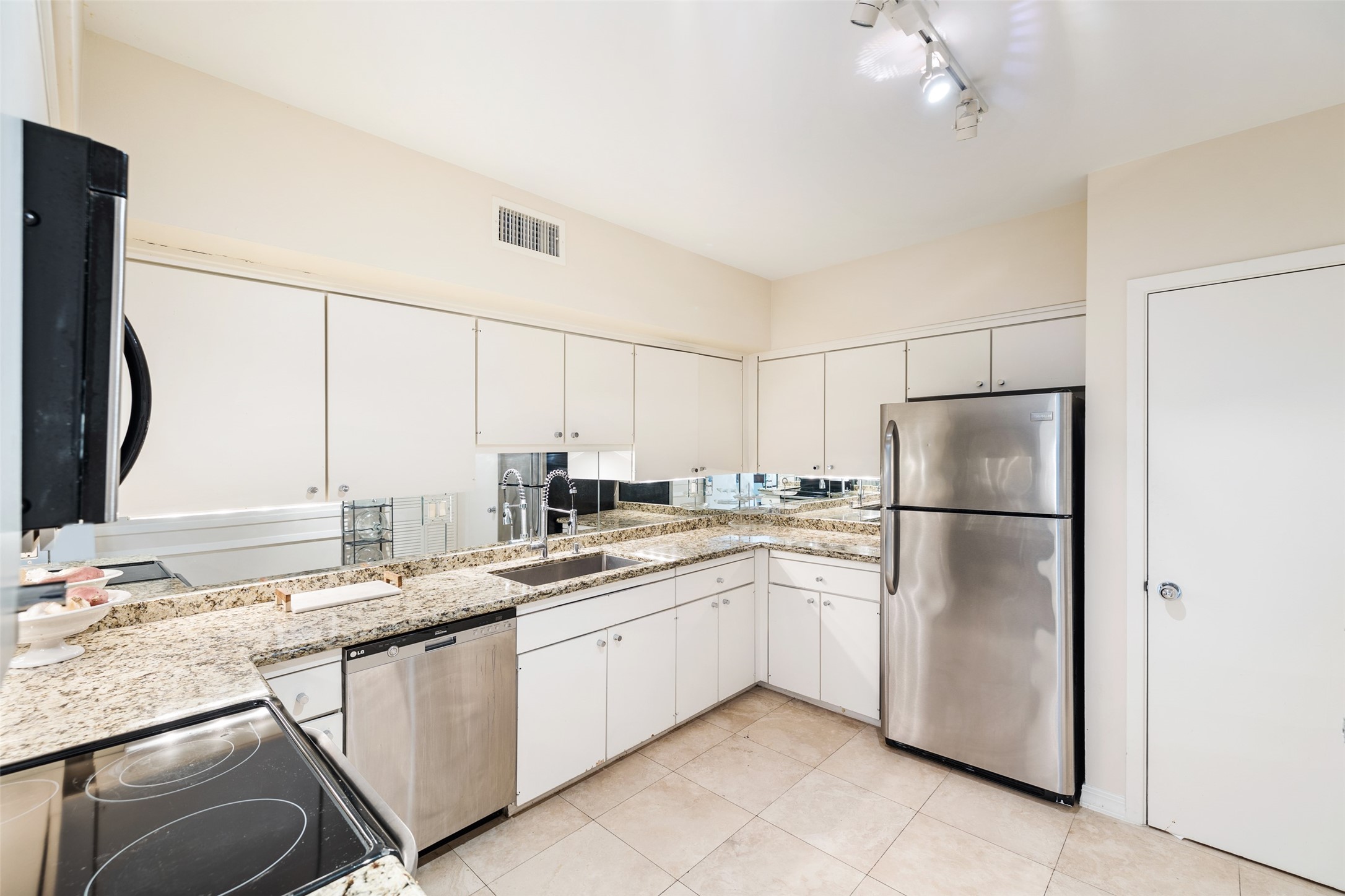 The Kitchen is equipped with stainless steel appliances and granite counter tops. Pantry with built in shelving.