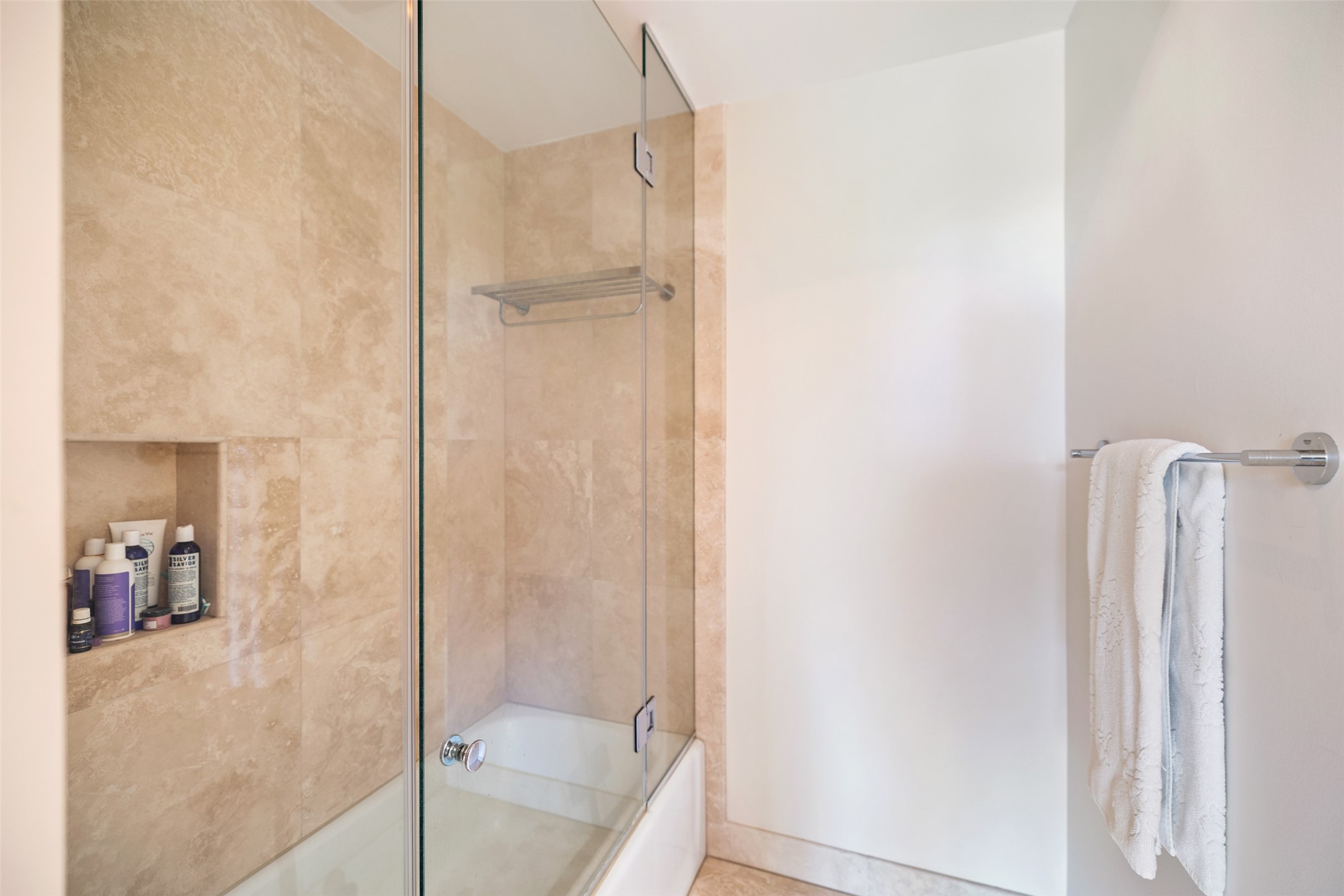 The primary bathroom also has a tub and shower with frameless glass door.