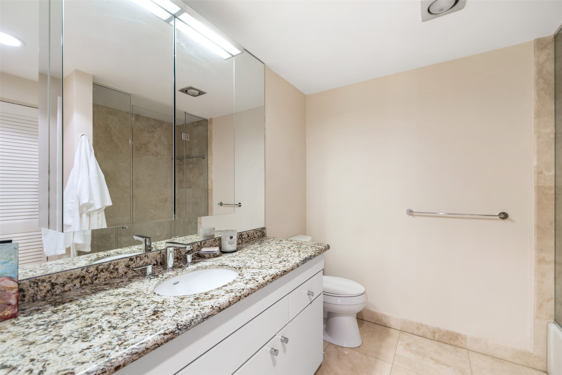 Secondary en-suite bathroom with granite countertops and wall mirrors.