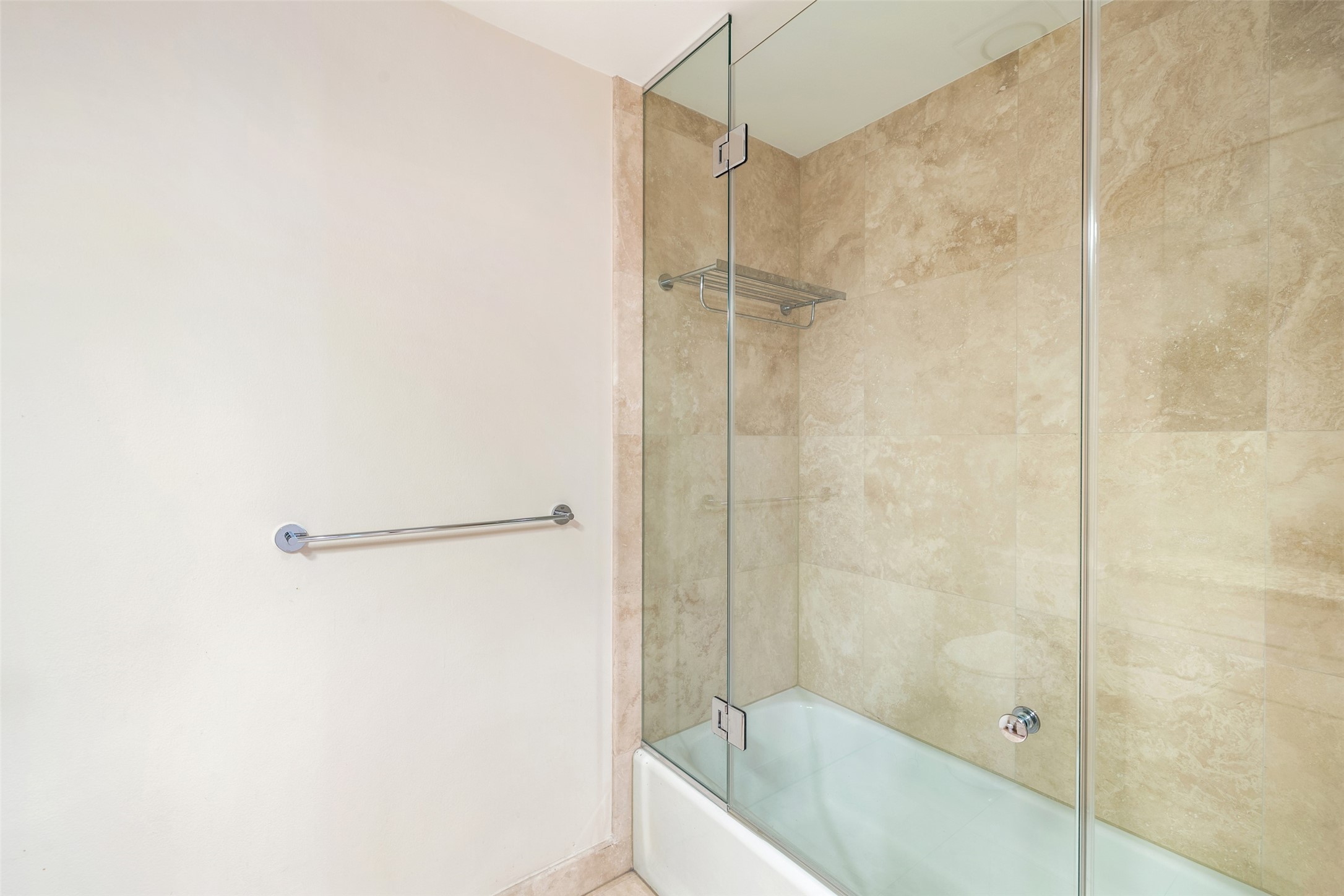 Secondary bathroom is also equipped with a shower and tub with frameless glass door.