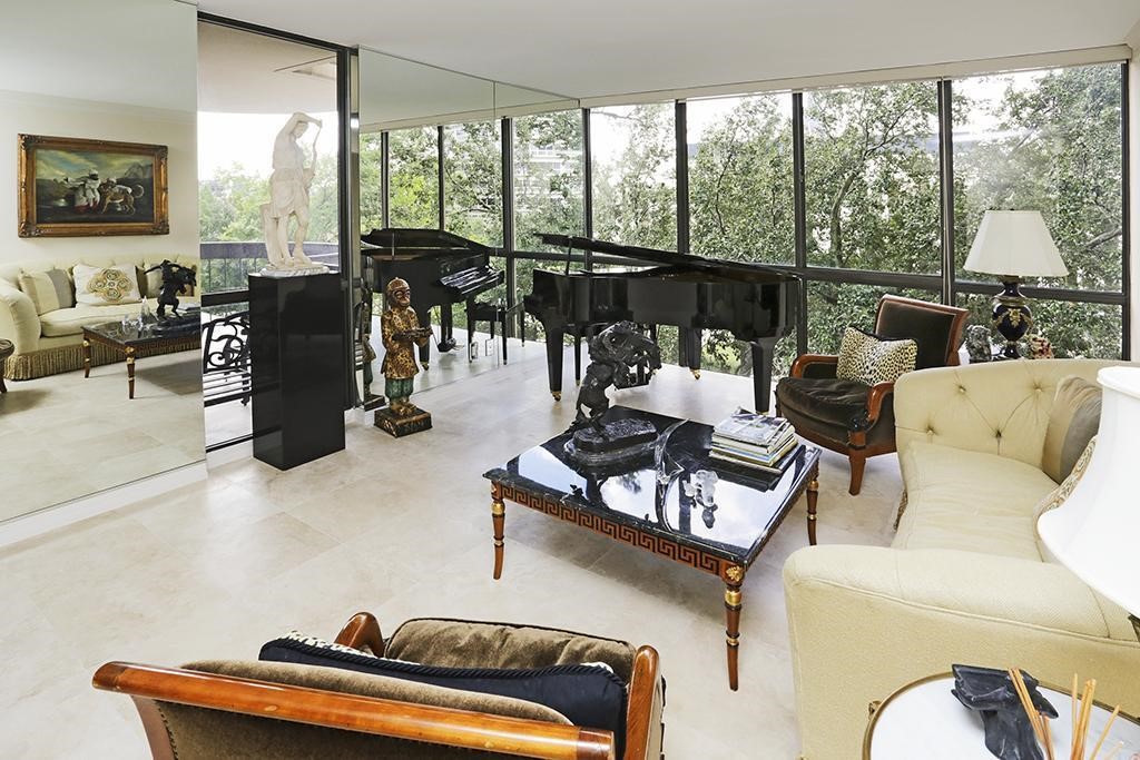 The living room is expansive and provides floor to ceiling windows with custom window treatments.