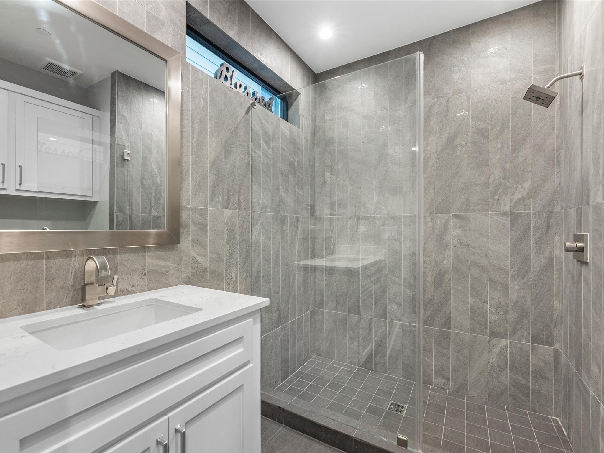 The first floor bathroom features a walk-in shower with tile surround, tile flooring, and sleek modern fixtures!