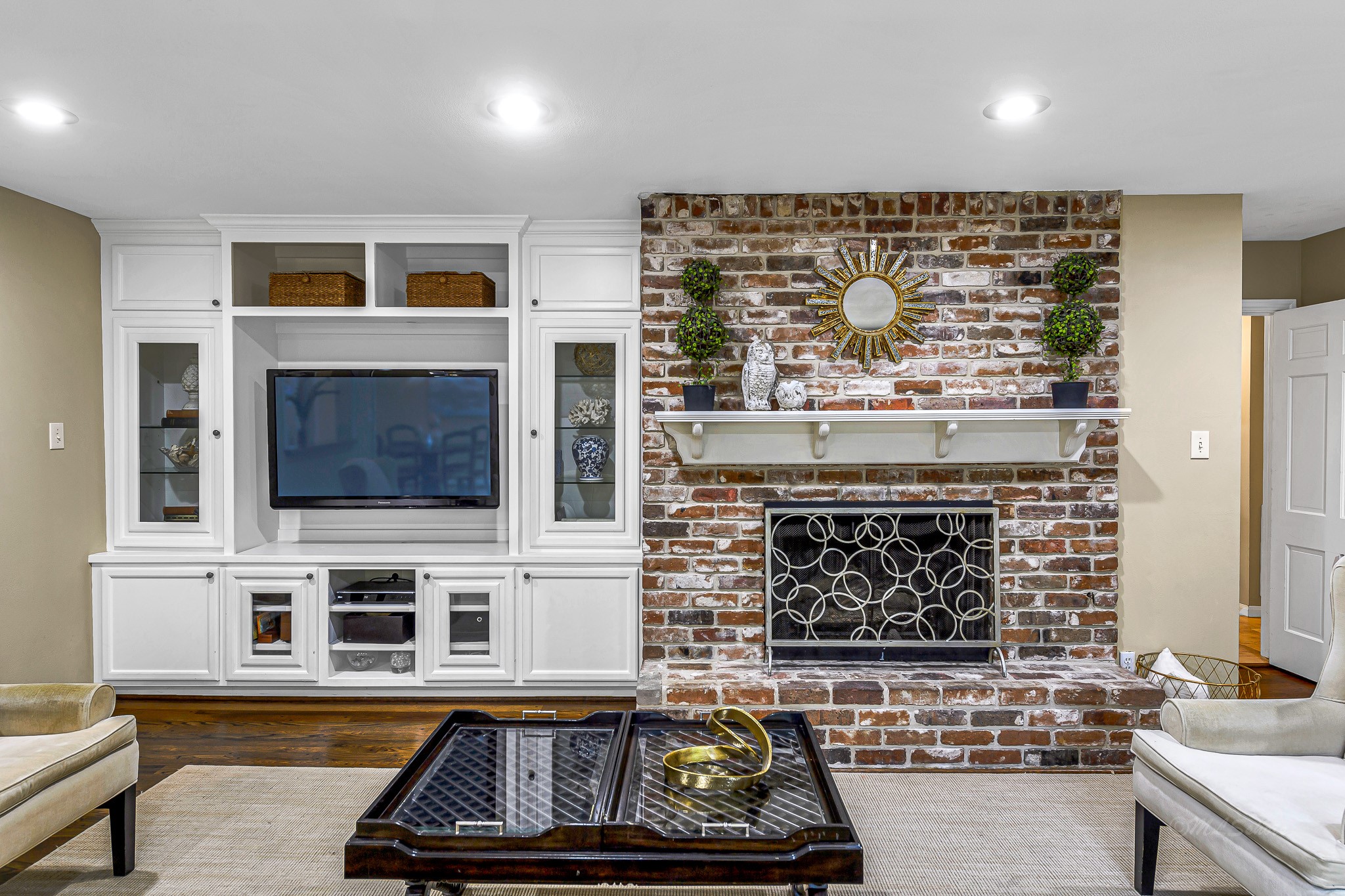 The centerpiece of the room is a gas log brick fireplace that bathes the space in a soft, warm glow.