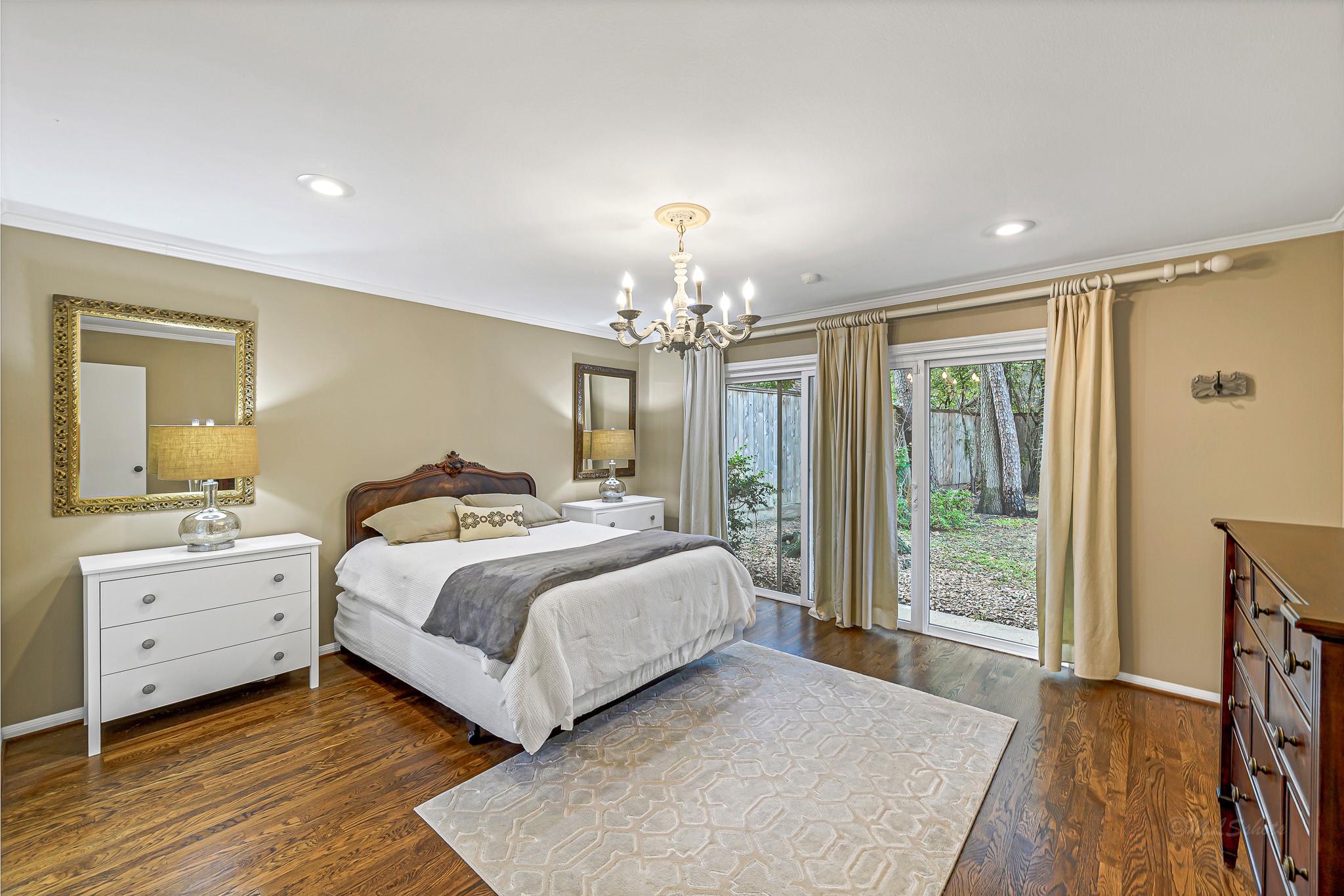 The Primary Bedroom embodies comfort and timeless elegance. The rich wood floors, warm color palette, crown molding, double closets, and private patio access create a haven of comfort in timeless elegance.