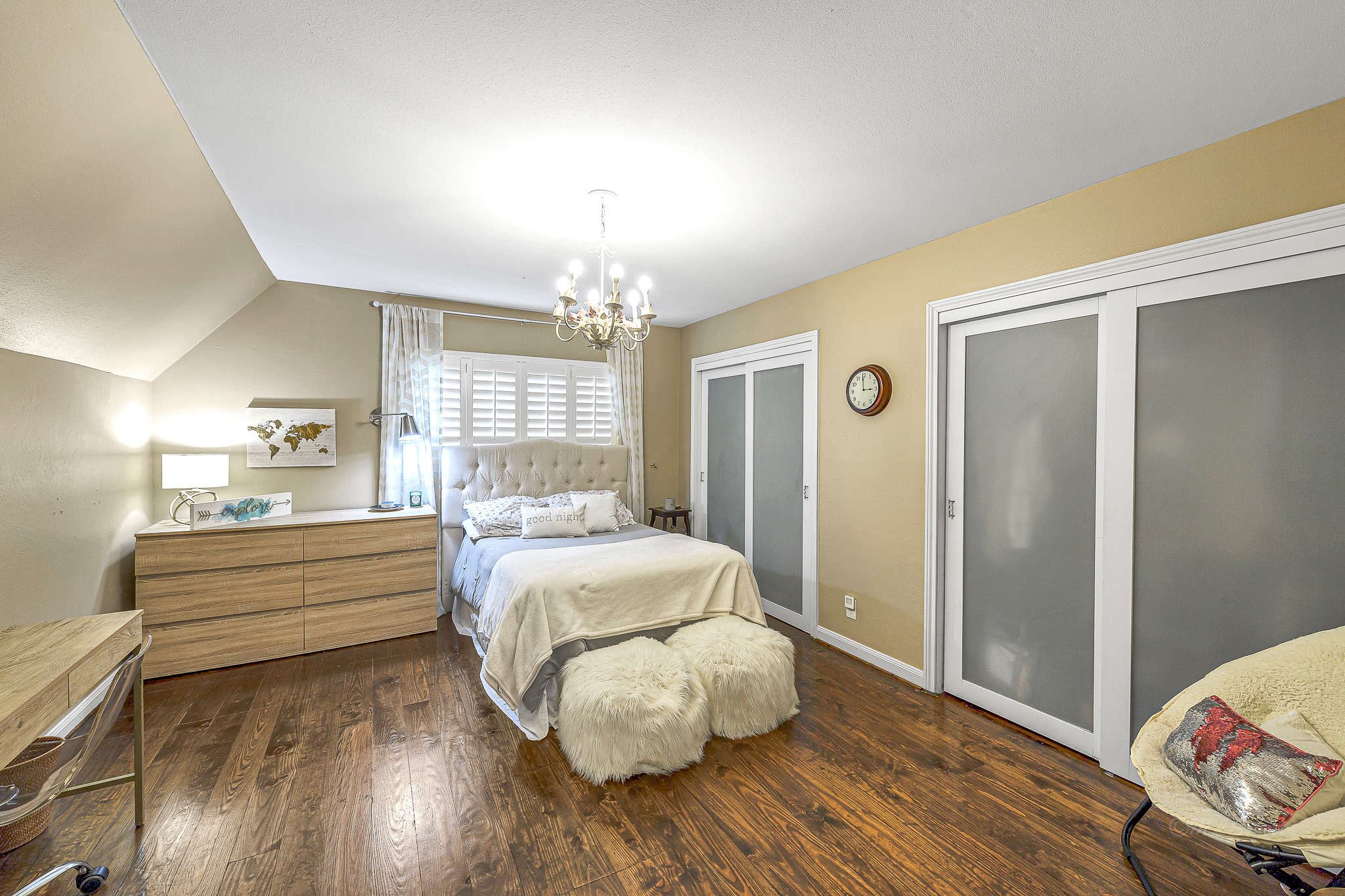 This inviting secondary retreat located upstairs is adorned with a warm color palette, wood flooring, and double closets, creating a space that's both cozy and highly functional.