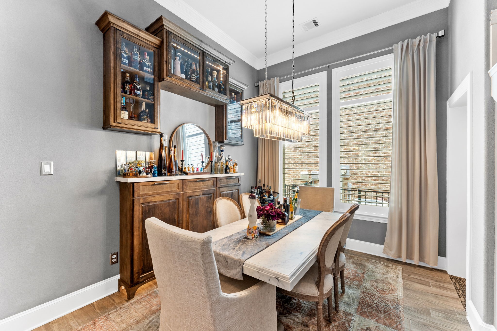 Like a photo from a magazine with custom built in buffet, led lighted glass cabinets and Restoration Hardware chandelier. Don't miss the custom bar to the right, under the stairs!