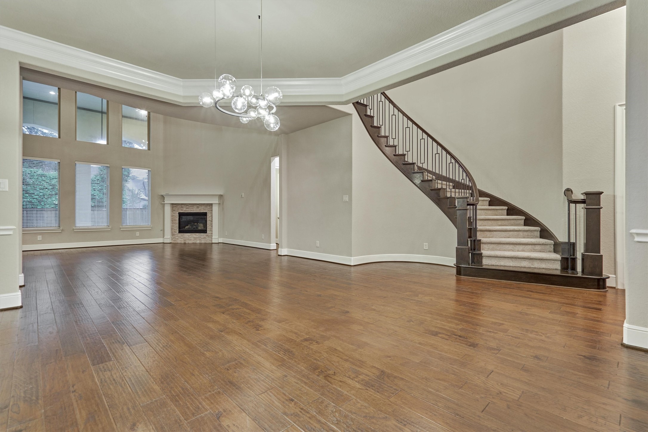 The bright and airy family room, featuring stunning two story windows and warm hardwood flooring.
