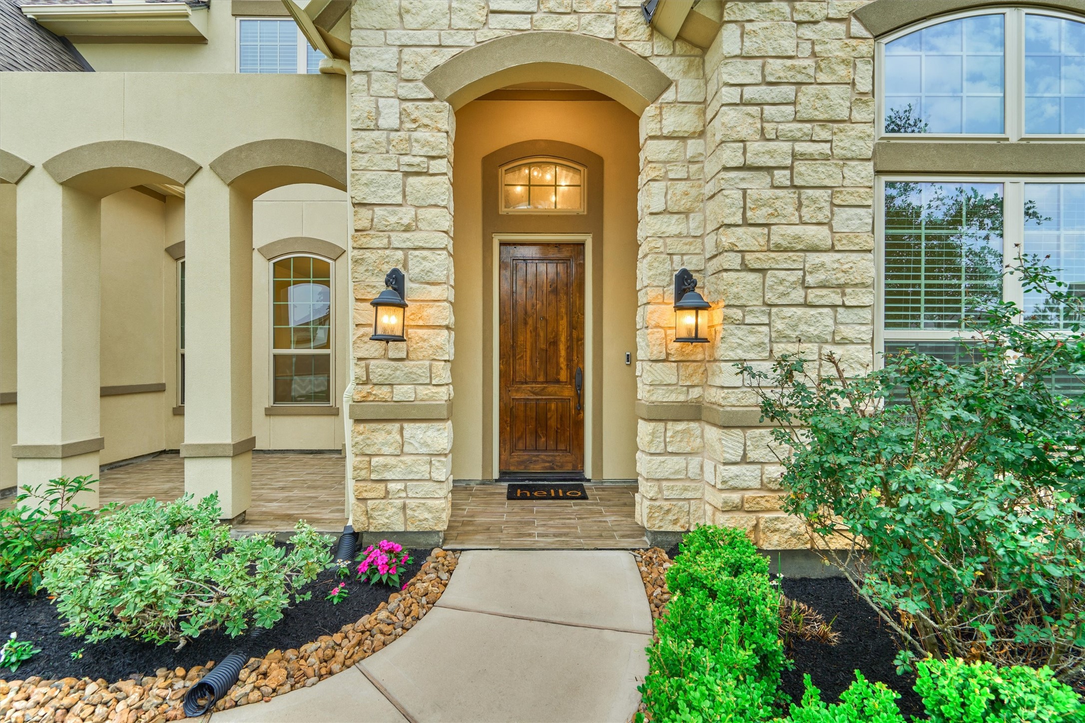 Stately front door and entryway leading into a grand foyer with high ceilings and natural light.