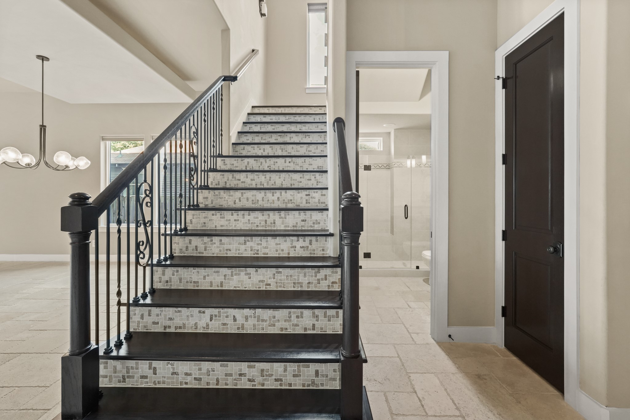 Reach the second floor via this breathtaking custom tile and wood stairway.